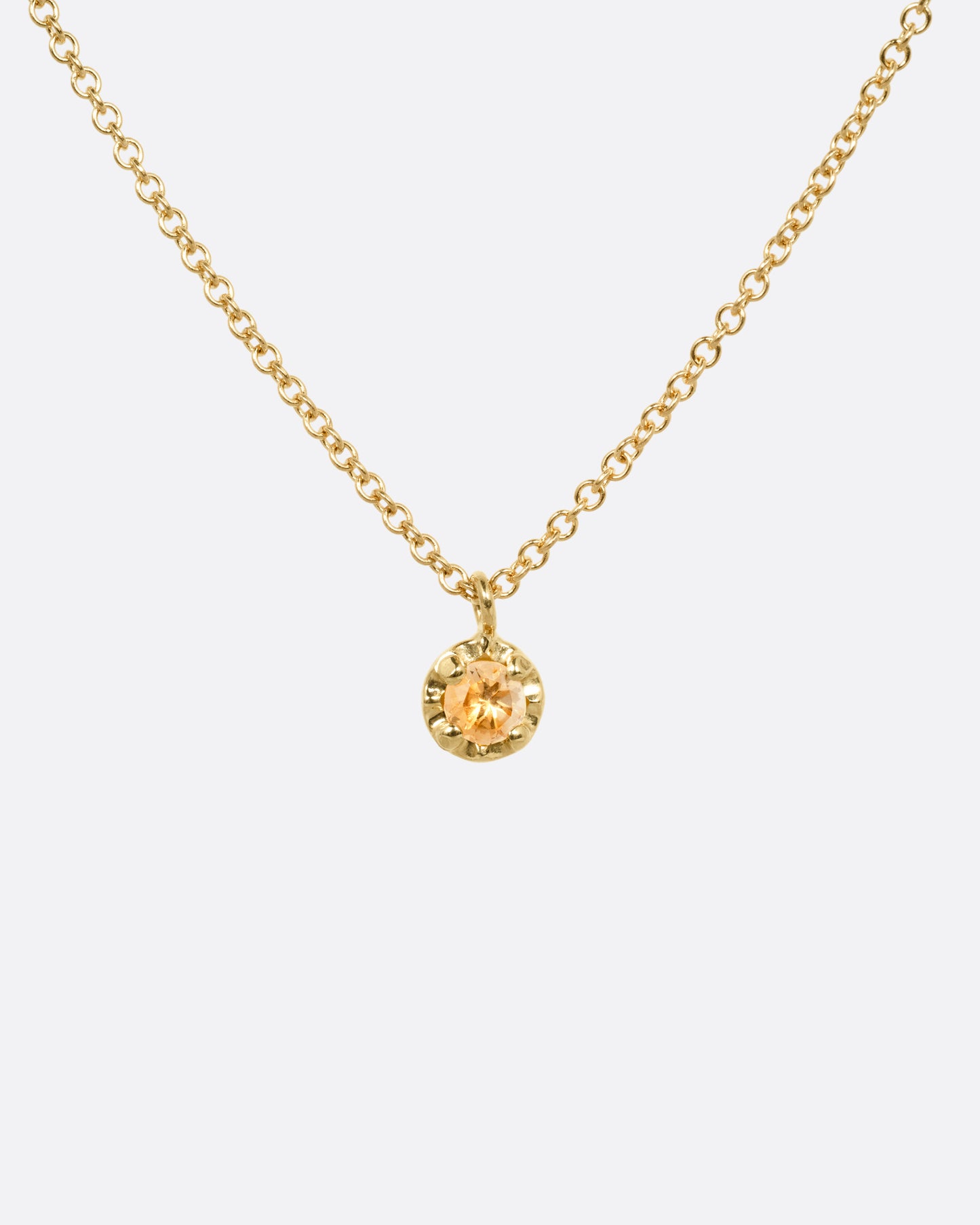 A yellow gold cable chain necklace with a  prong set citrine, shown from the front.