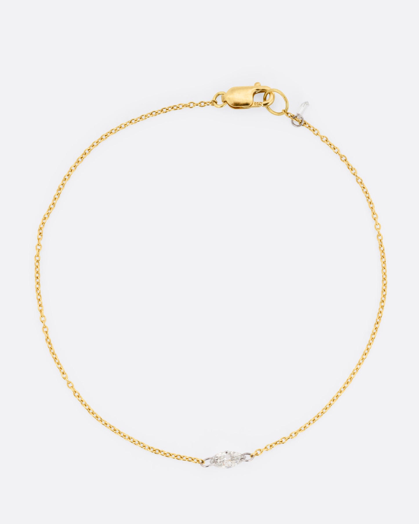 A  yellow gold cable chain bracelet with platinum jump rings and a free set marquise diamond.  Shown from the front.