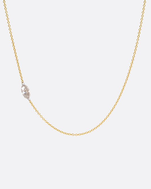 A yellow gold cable chain necklace with platinum jump rings and a free set marquise diamond, asymmetrically set. Shown from the front. 