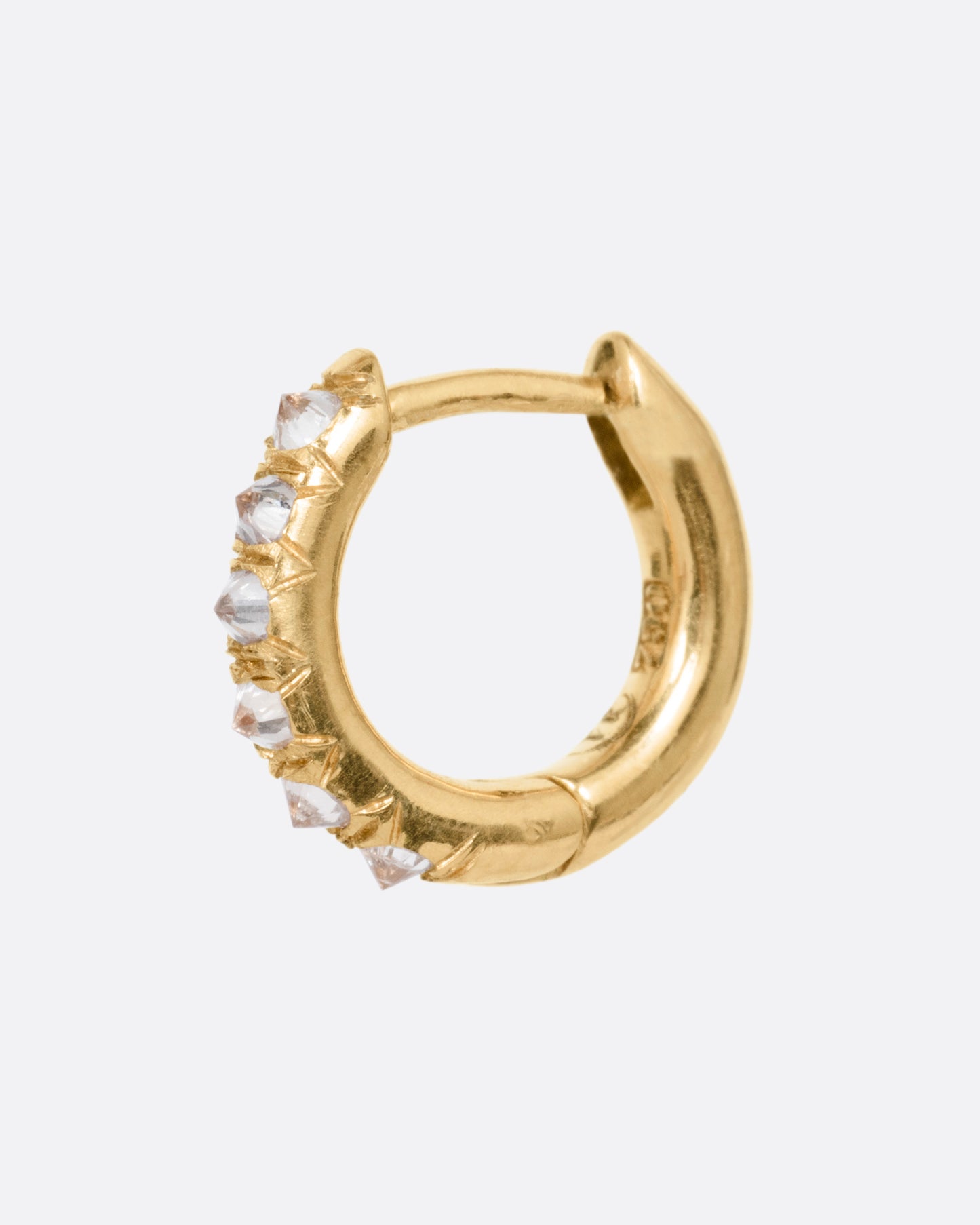 A yellow gold hoop earring with reverse set diamonds. Shown from the side.