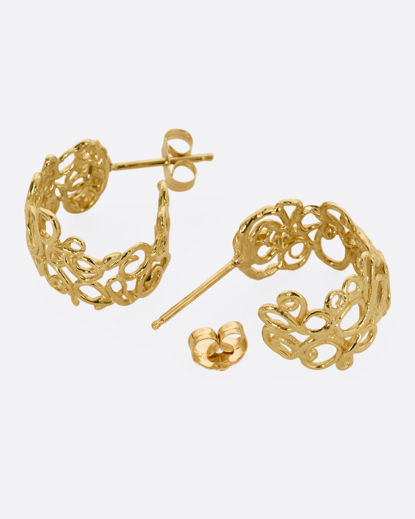 yellow gold swirl hoop earrings shown lying flat