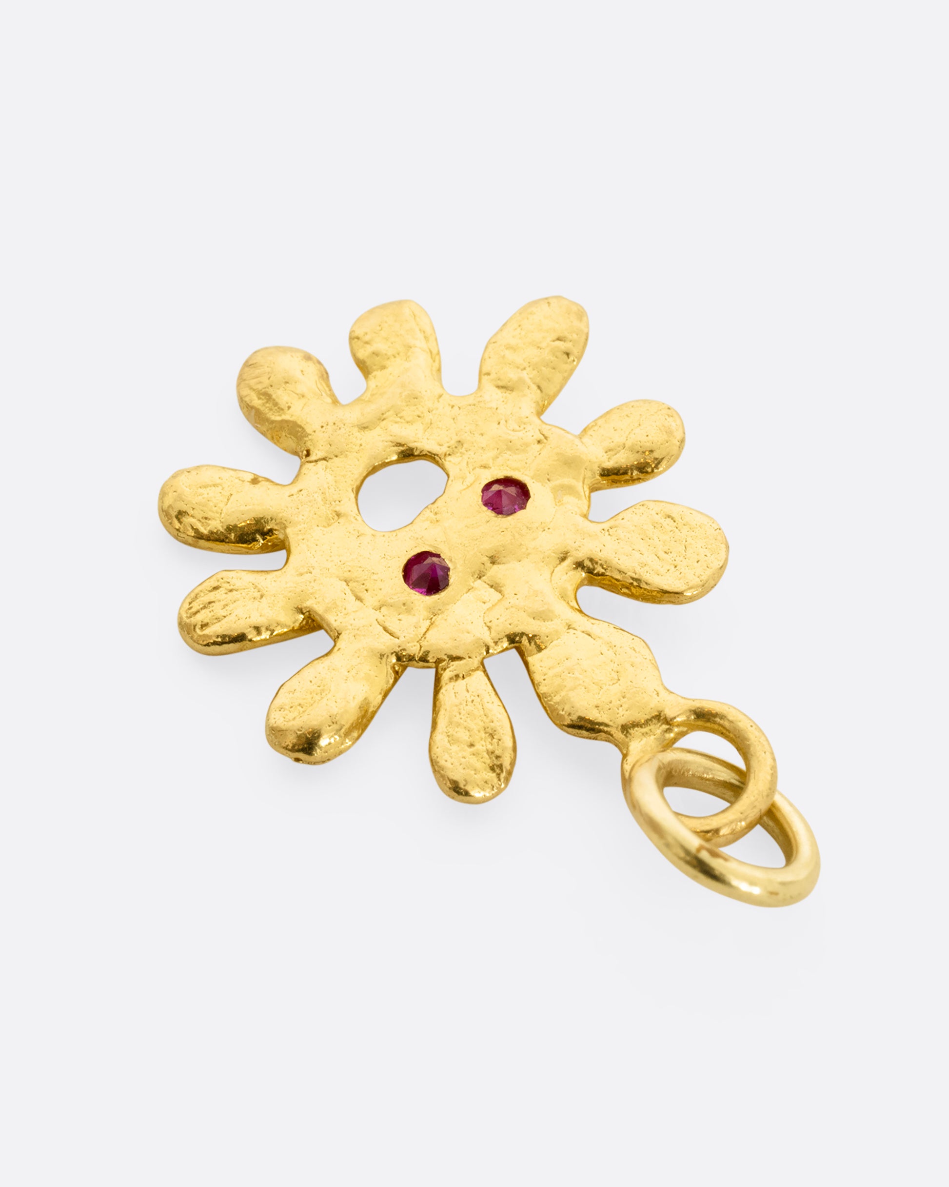 yellow gold sun pendant with ruby eyes shown from the back