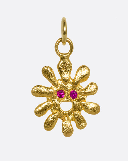 yellow gold sun pendant with ruby eyes shown from the front