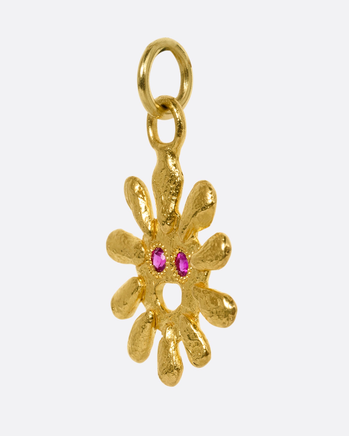 yellow gold sun pendant with ruby eyes shown from the side