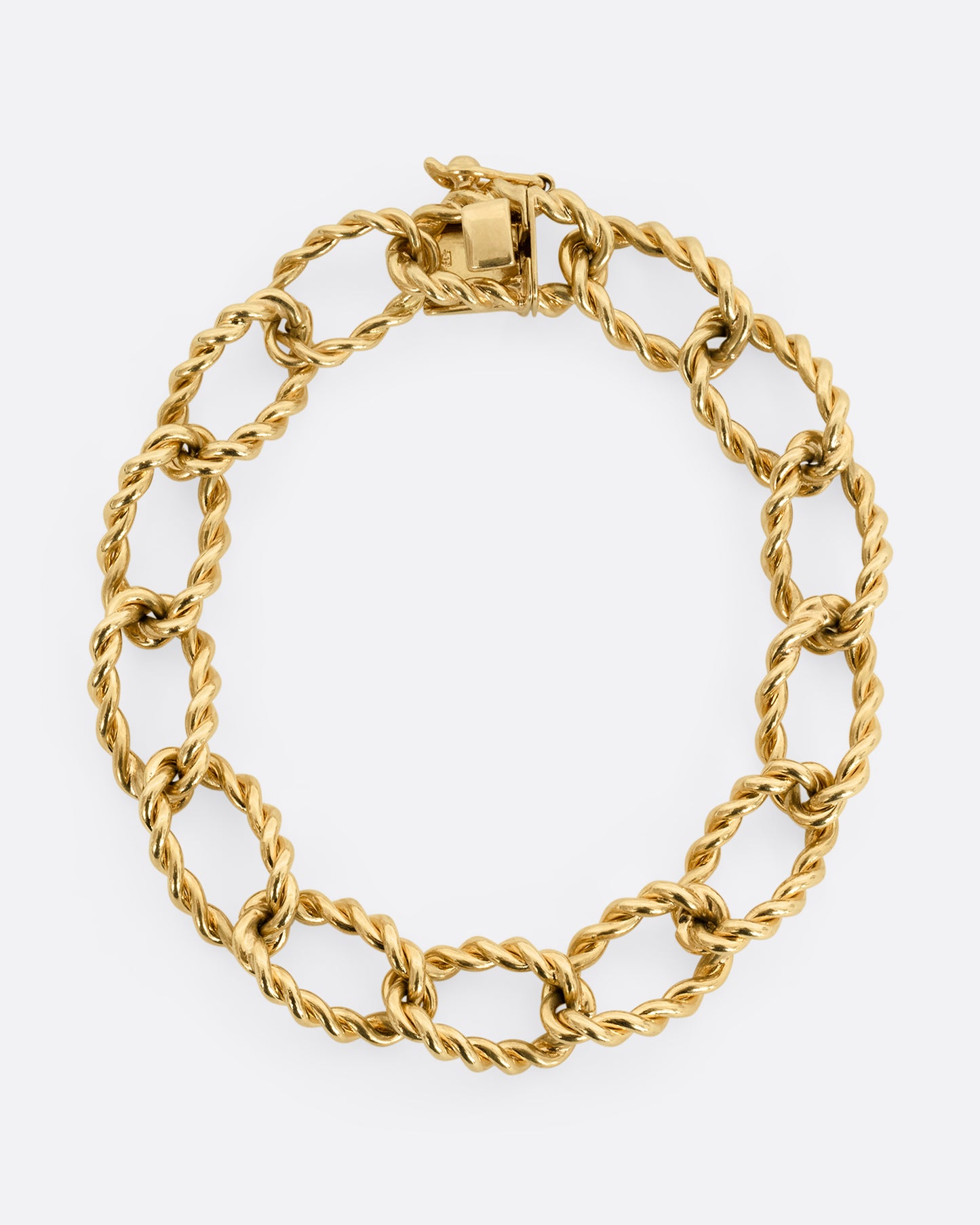 A yellow gold twisted link bracelet. Shown closed, laying flat.