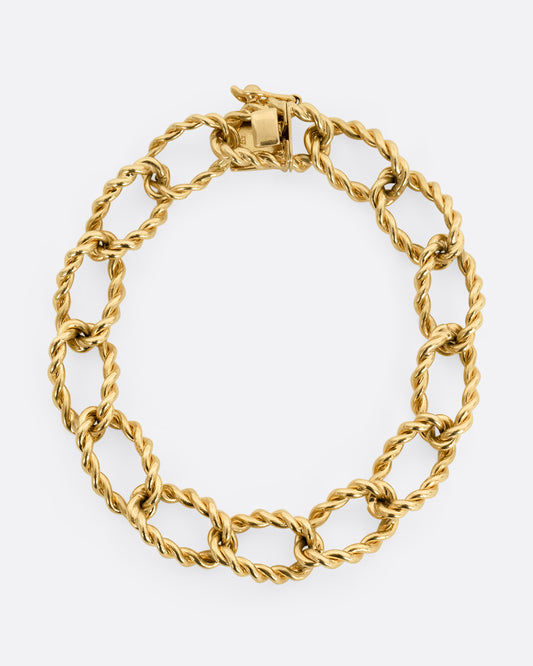 A yellow gold twisted link bracelet. Shown closed, laying flat.