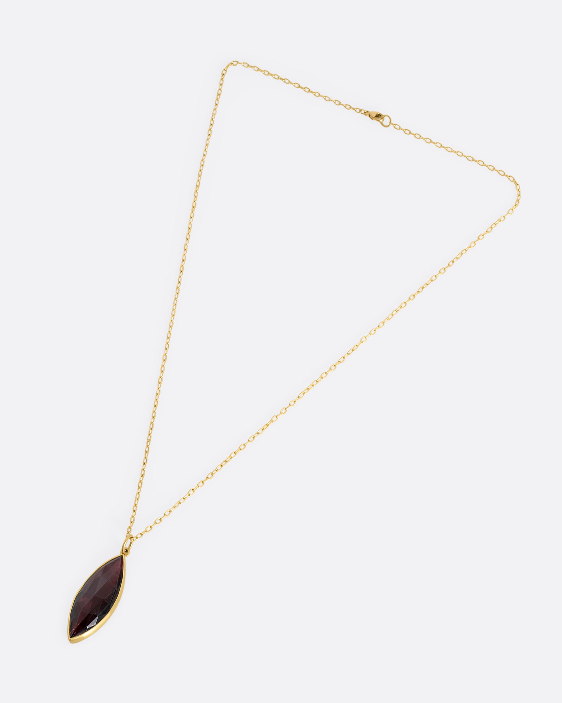 yellow gold necklace with navette shaped garnt shown from afar