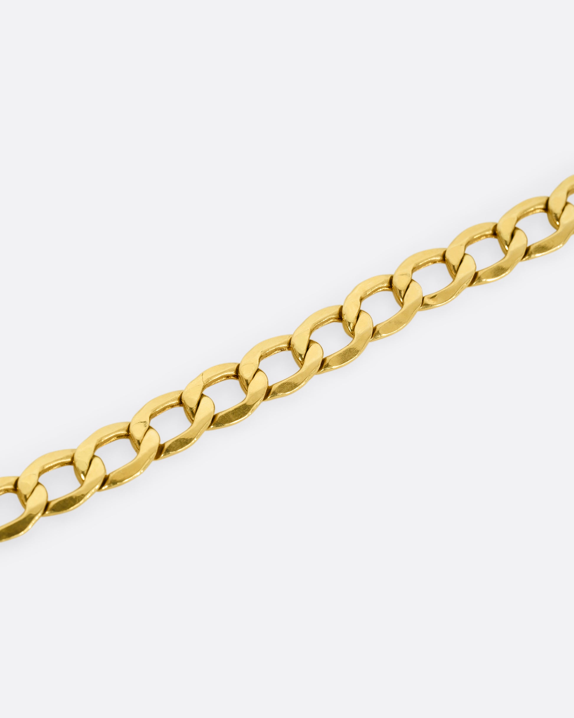 A high karat yellow gold Thai bhat chain. Shown close up on the links.