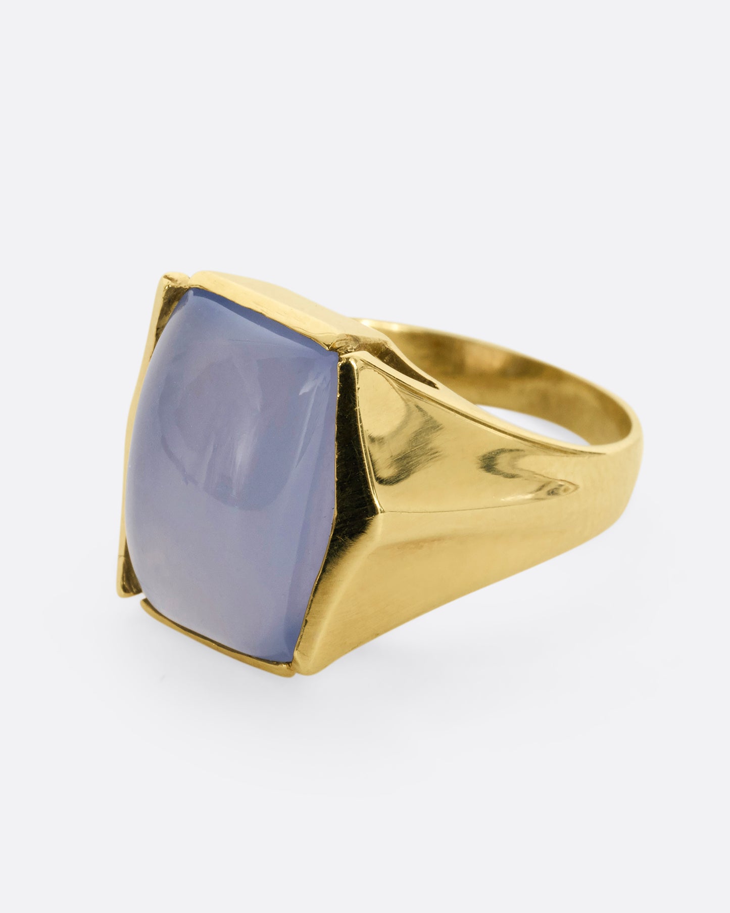 A yellow gold ring with a rectangular chalcedony face. Shown from the side.