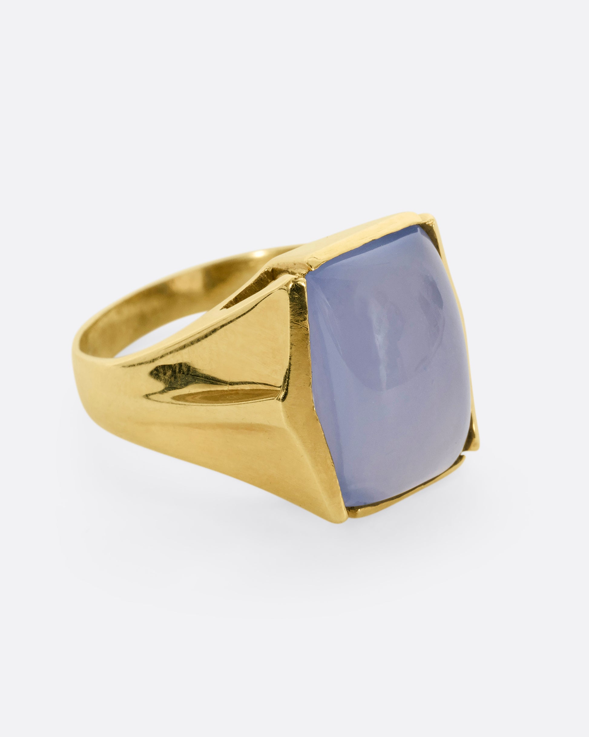 A yellow gold ring with a rectangular chalcedony face. Shown from the side.