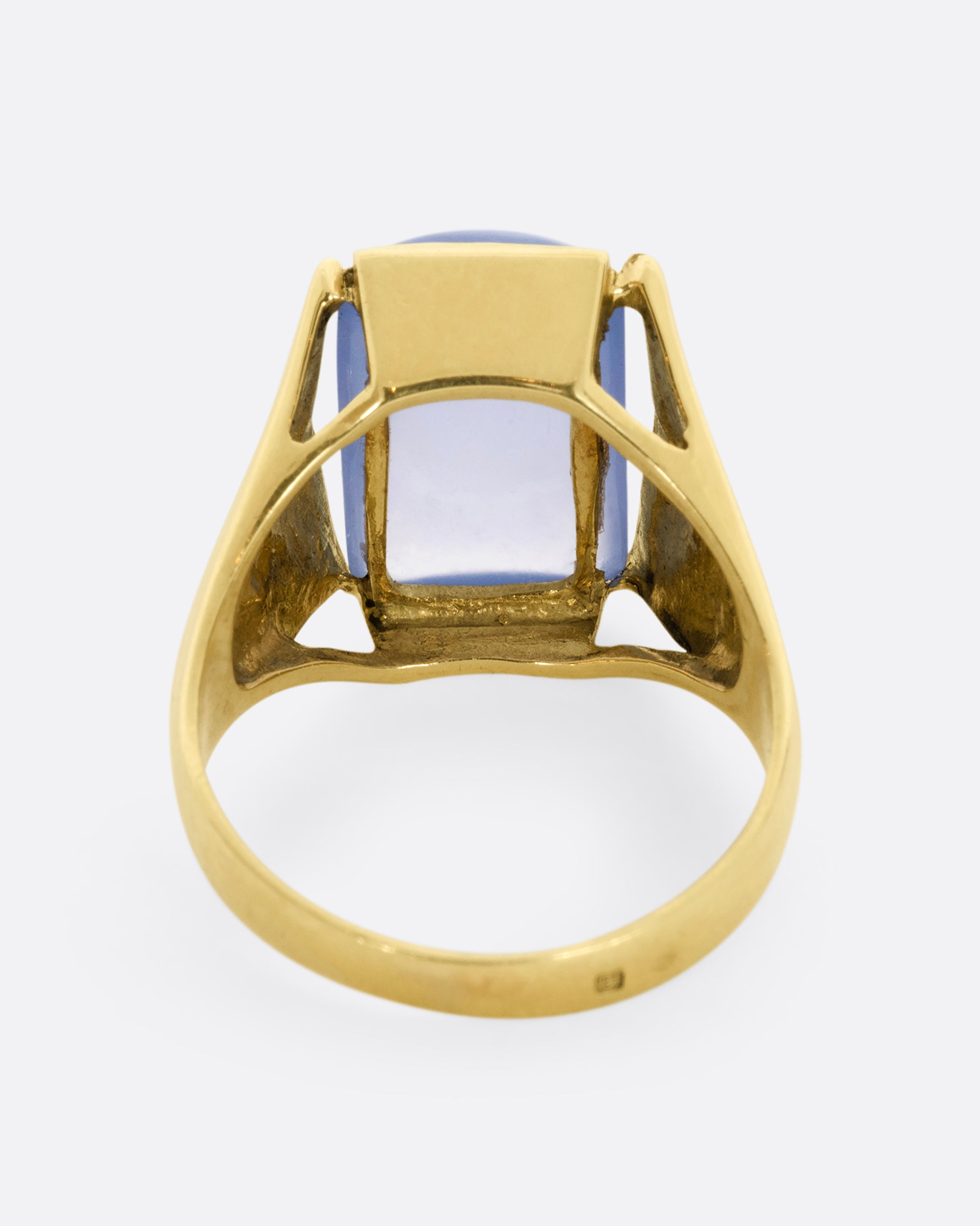 A yellow gold ring with a rectangular chalcedony face. Shown from the back.