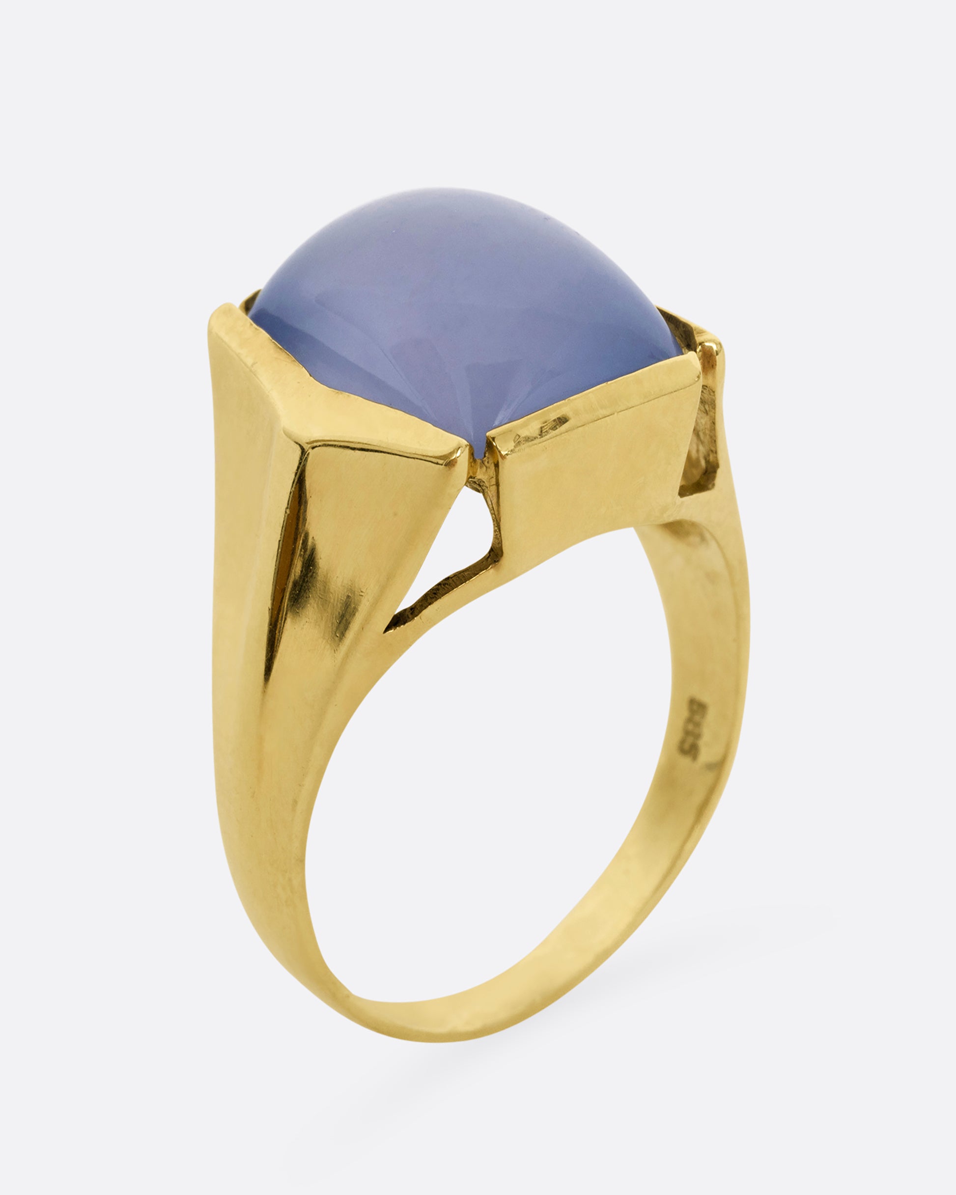 A yellow gold ring with a rectangular chalcedony face. Shown from the side, standing up.