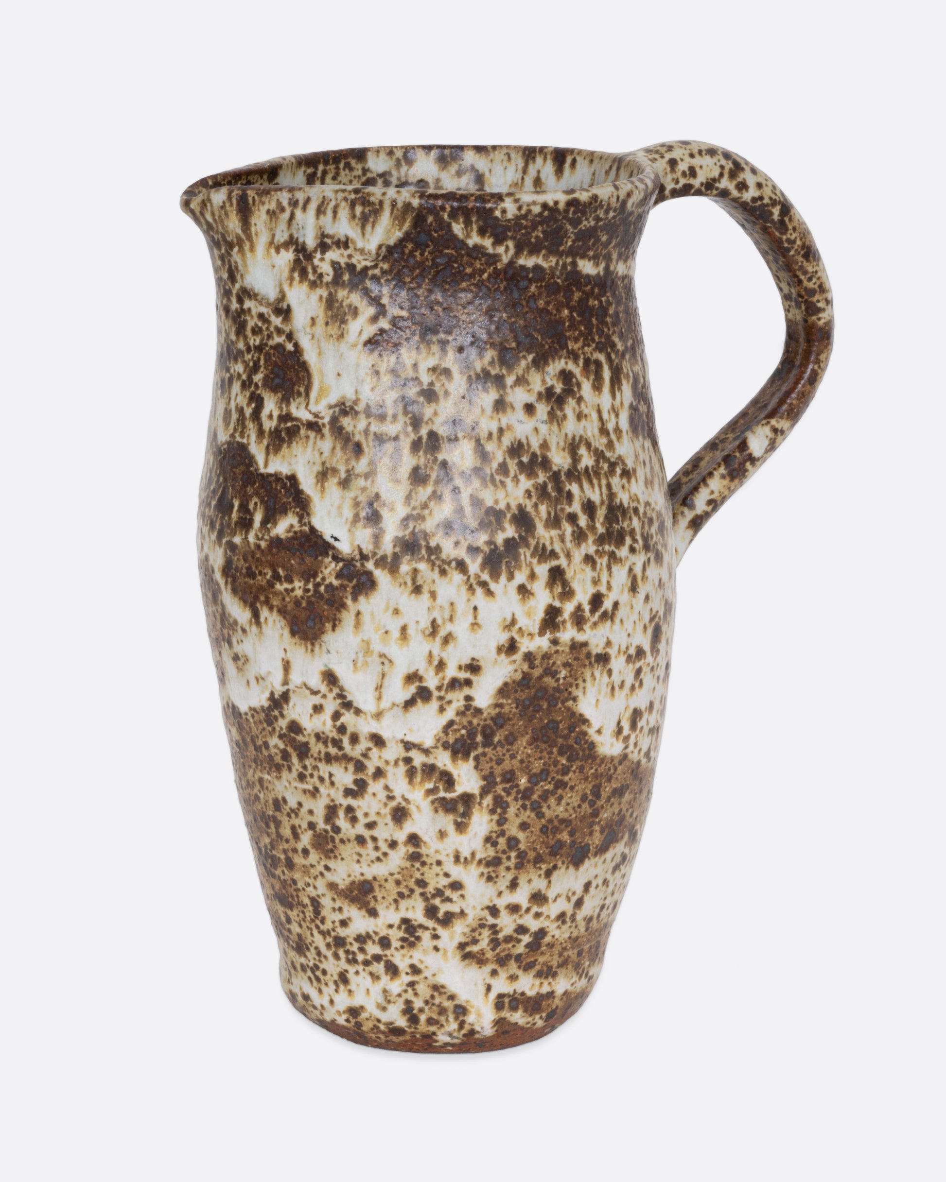 A speckled ceramic brown and cream pitcher, shown from the side.