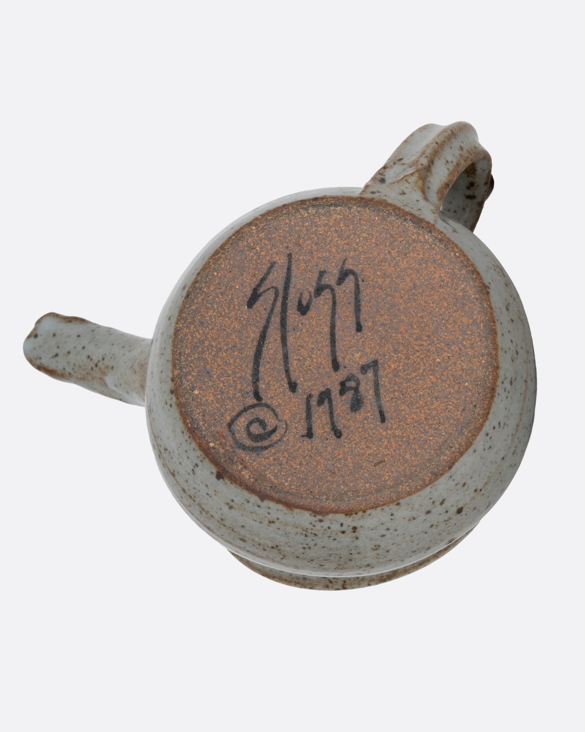 An aardvark mug with a long snout and open mouth spout. Shown from the bottom.