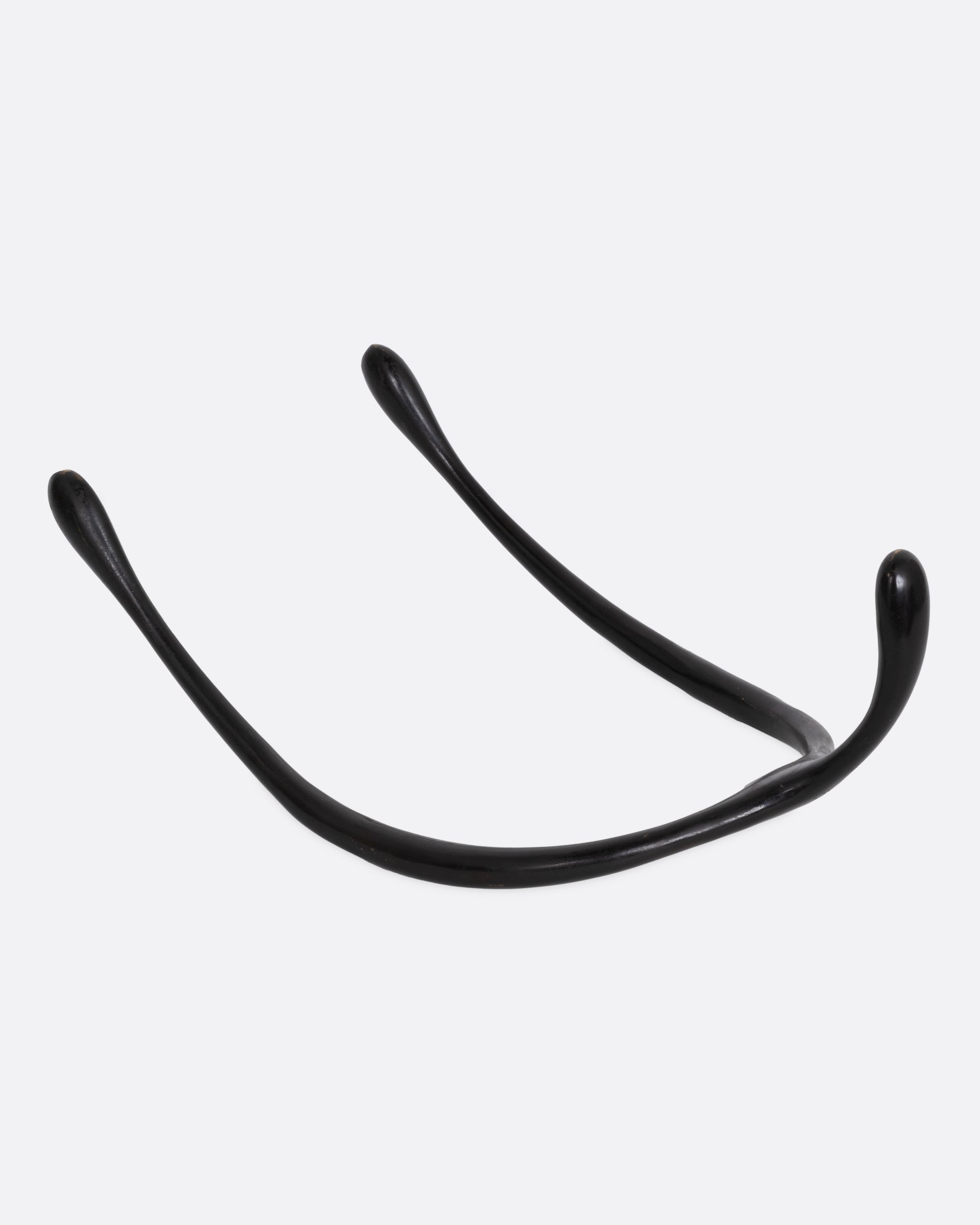 A black bronze wishbone sculpture, shown from the back.