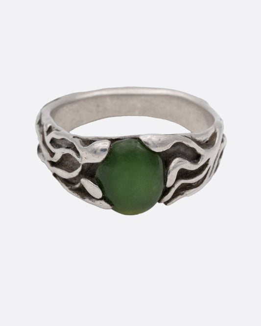 A silver ring with an oval jade at the center, shown from the front.