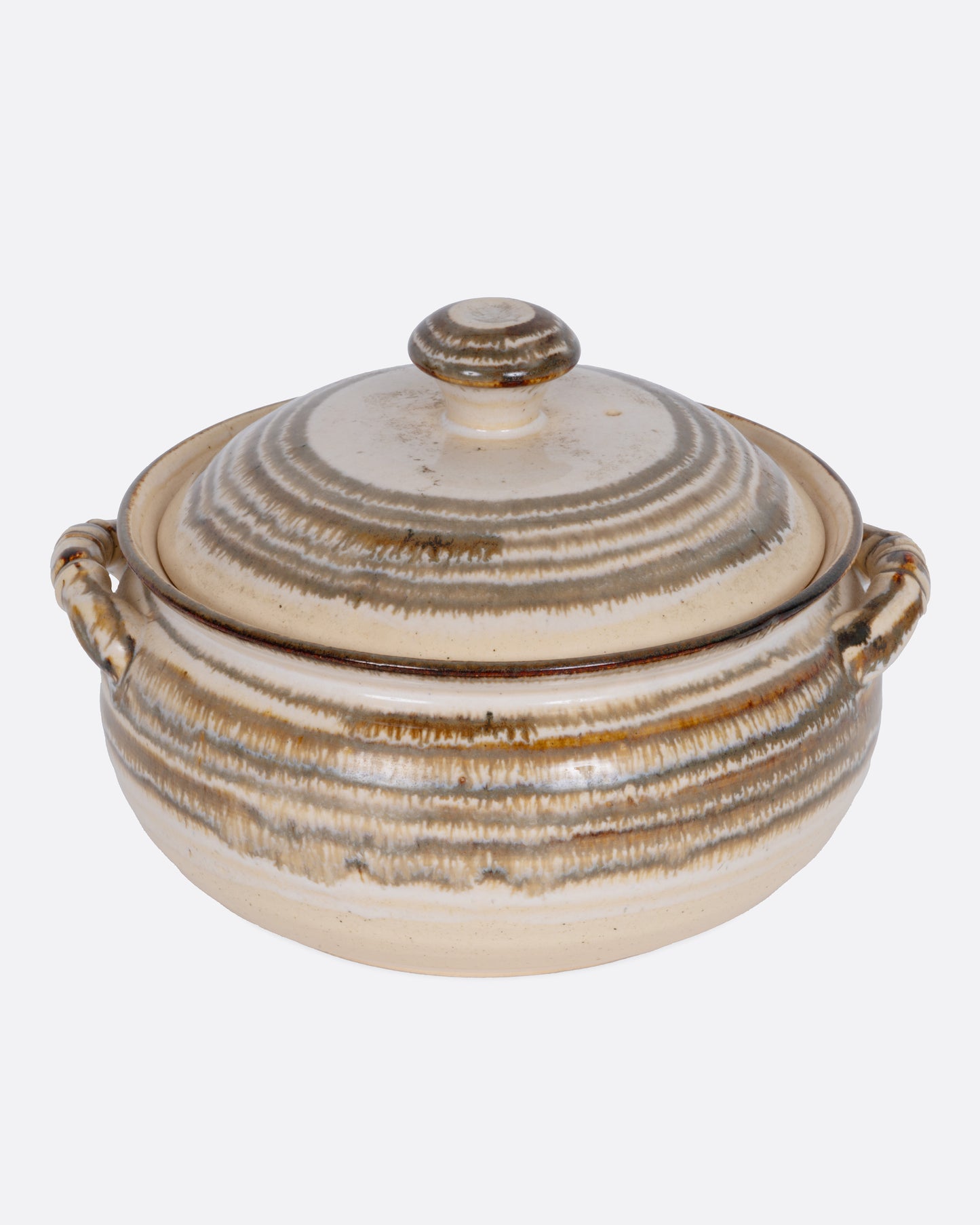 A beige striped casserole dish with dual handles and a domed lid, shown from the front.