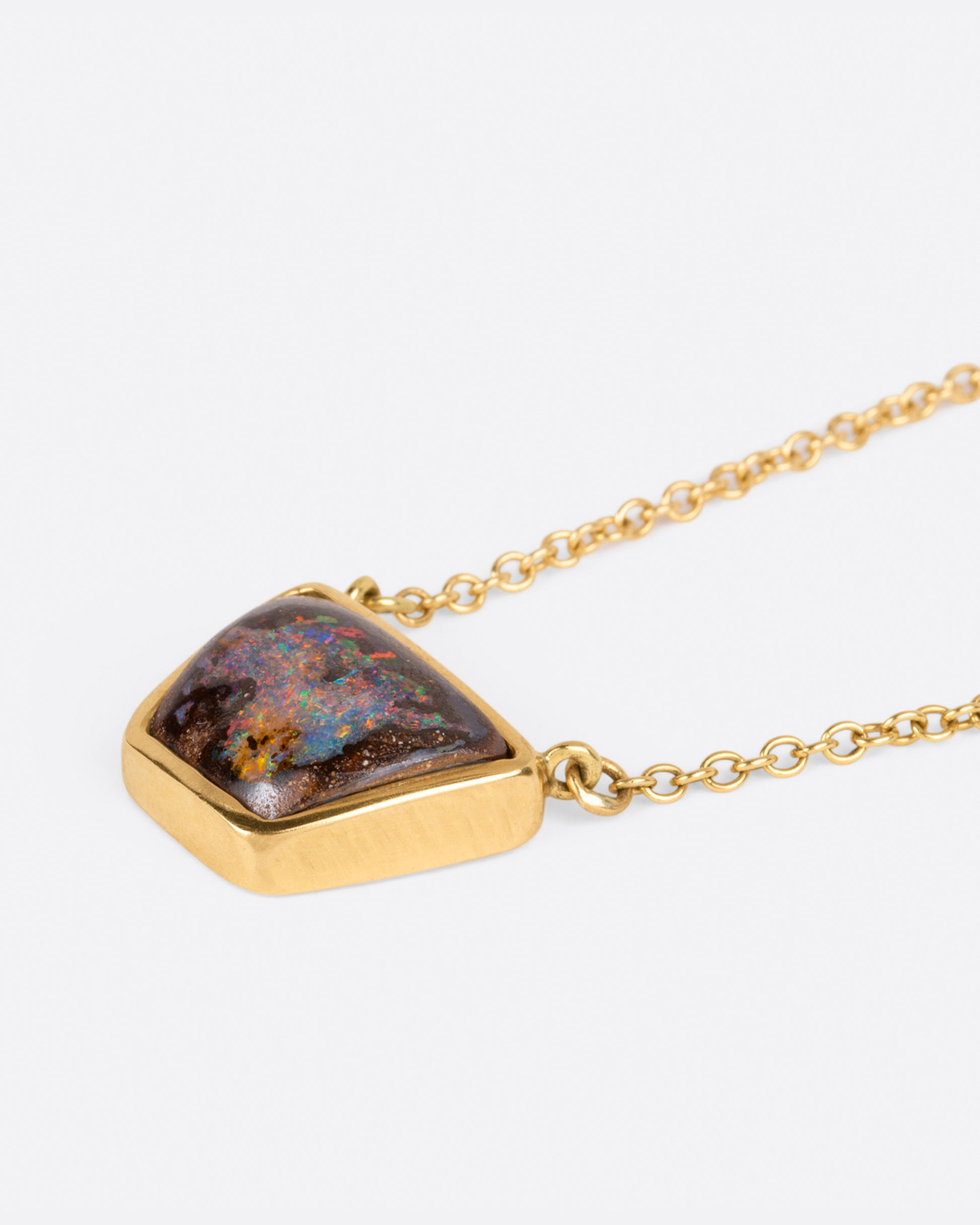 A flashy opalized wood is set in a simple bezel setting so the stone remains the star of this necklace.