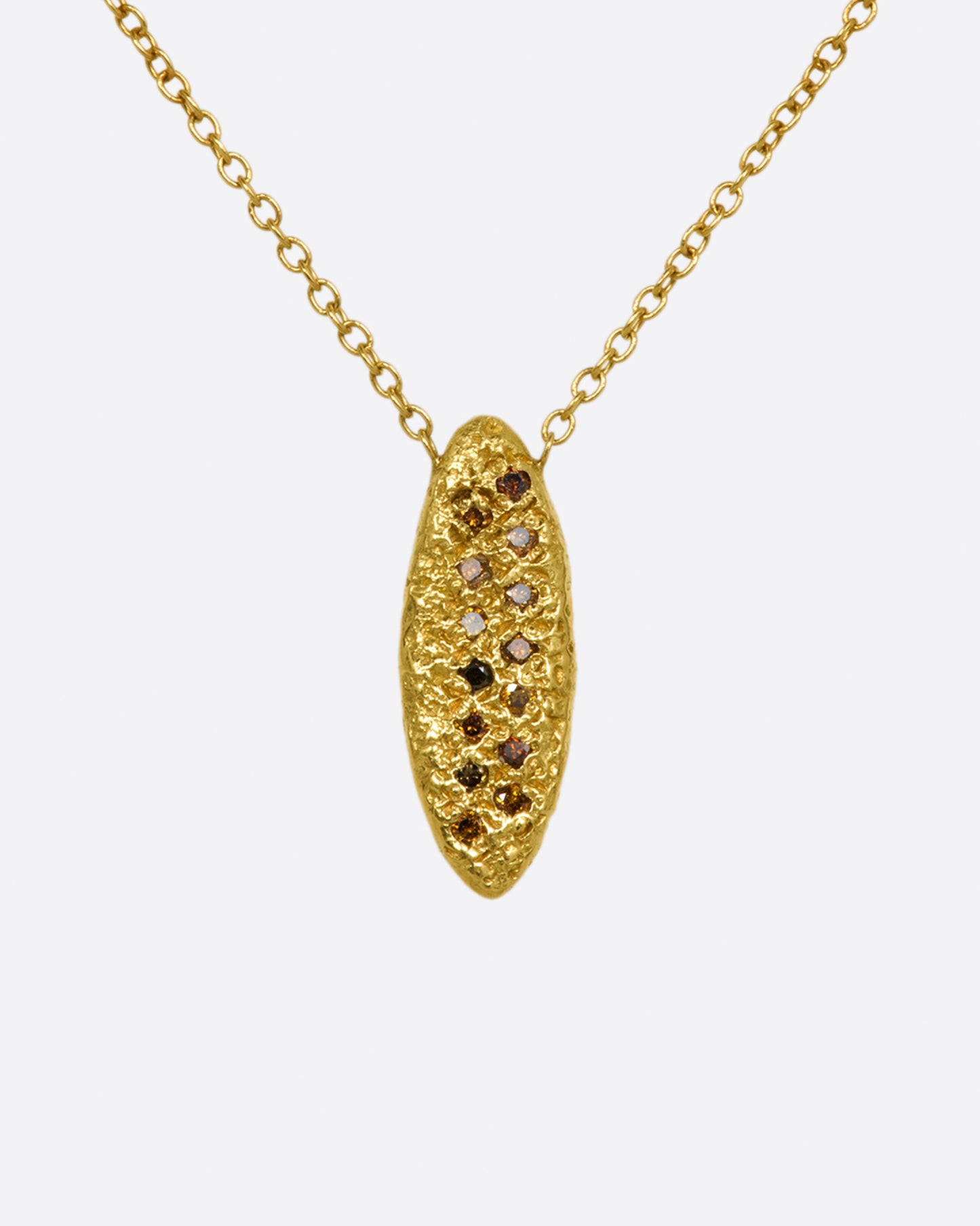 A yellow gold chain necklace with a marquise shape textured pendant, with two rows of red and brown diamonds.