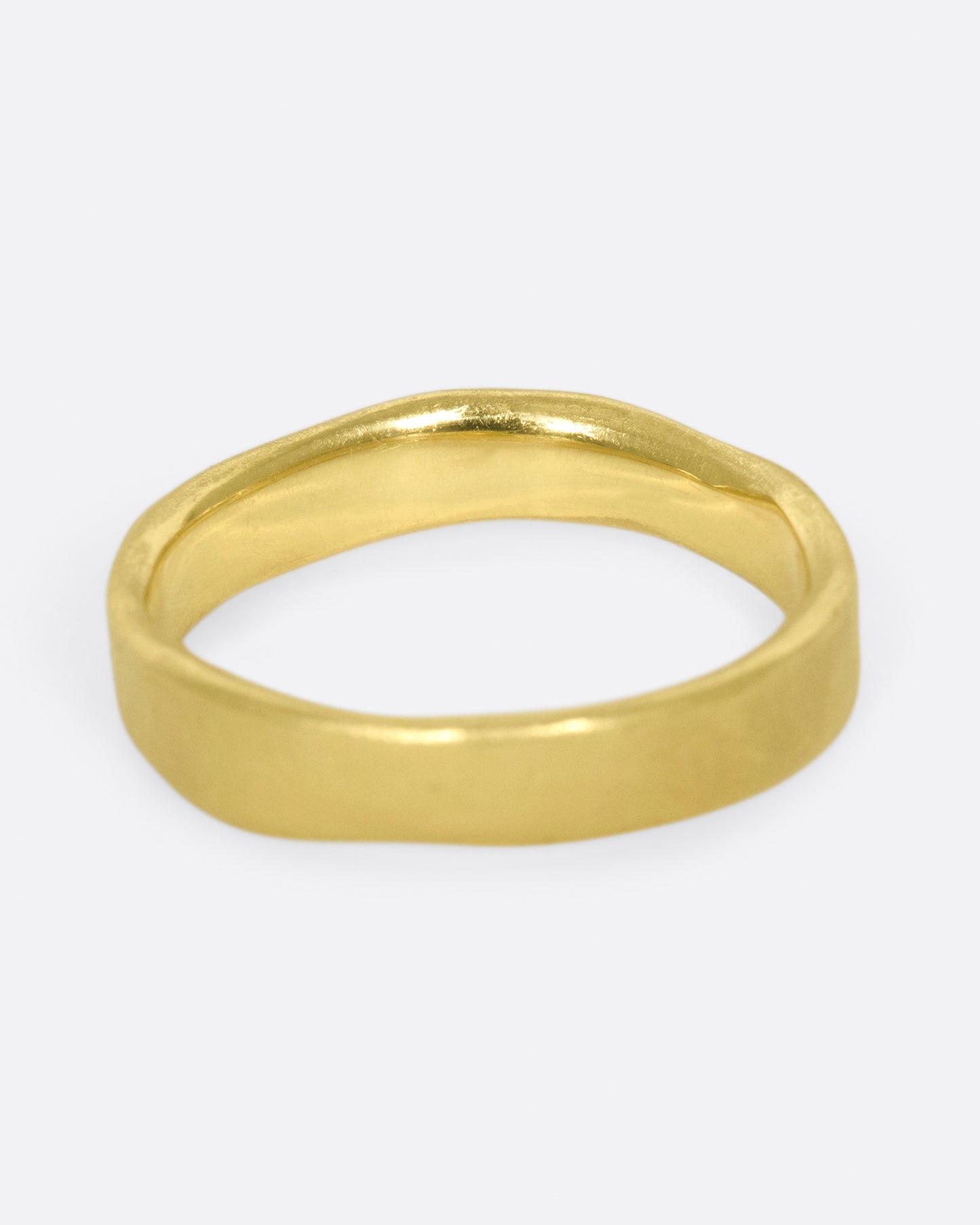 A hand-formed, brushed gold band with two rows of diamonds along half of it.