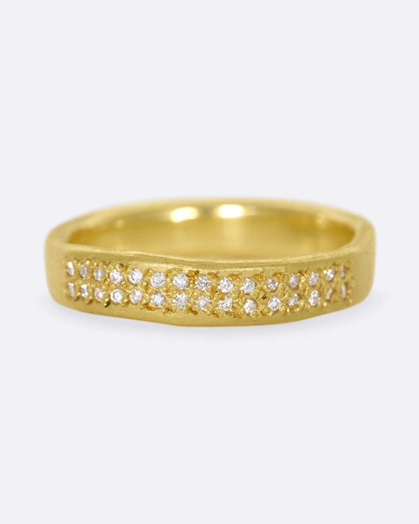A hand-formed, brushed gold band with two rows of diamonds along half of it.