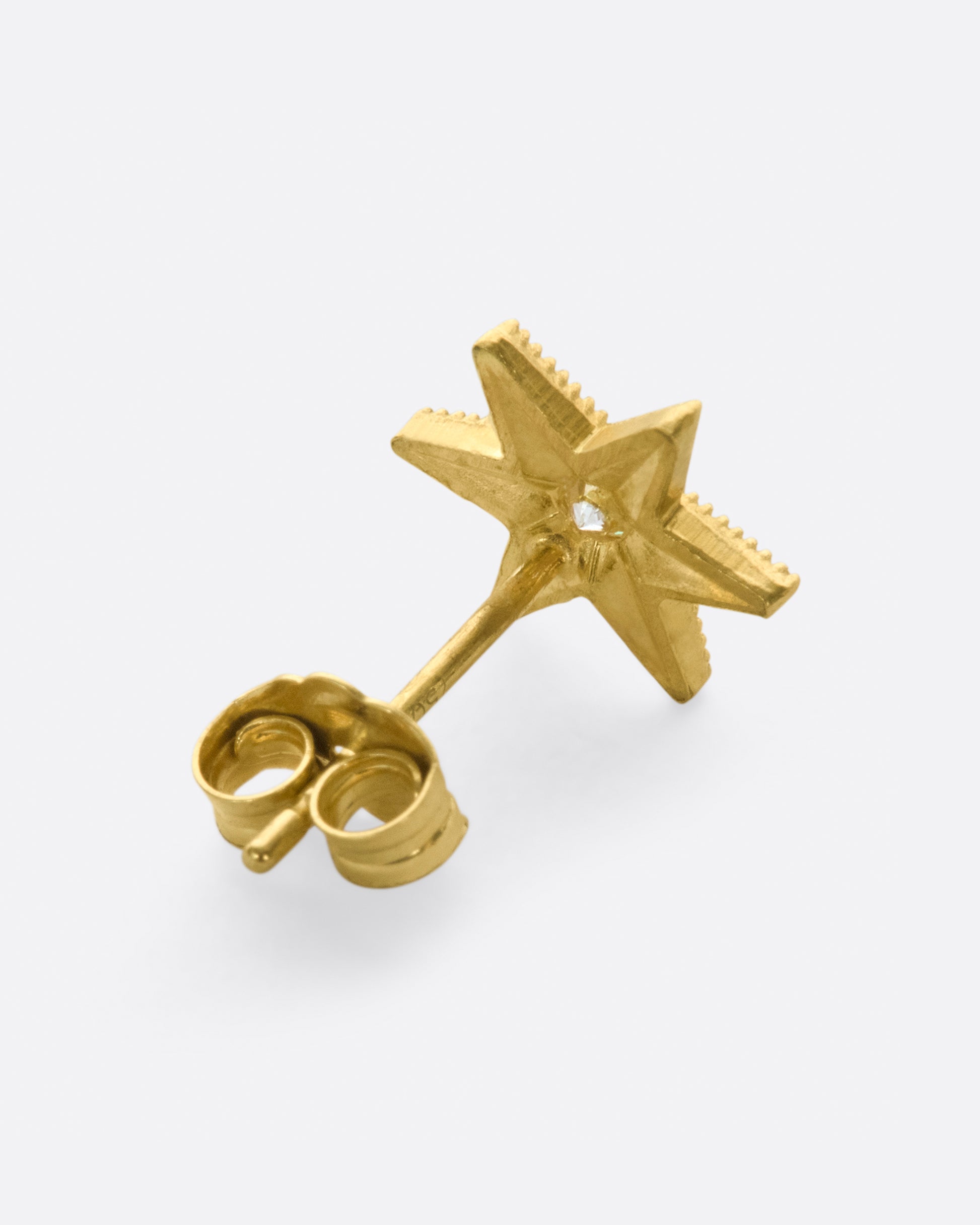 Yellow gold star stud earring with six points and millgrain details.