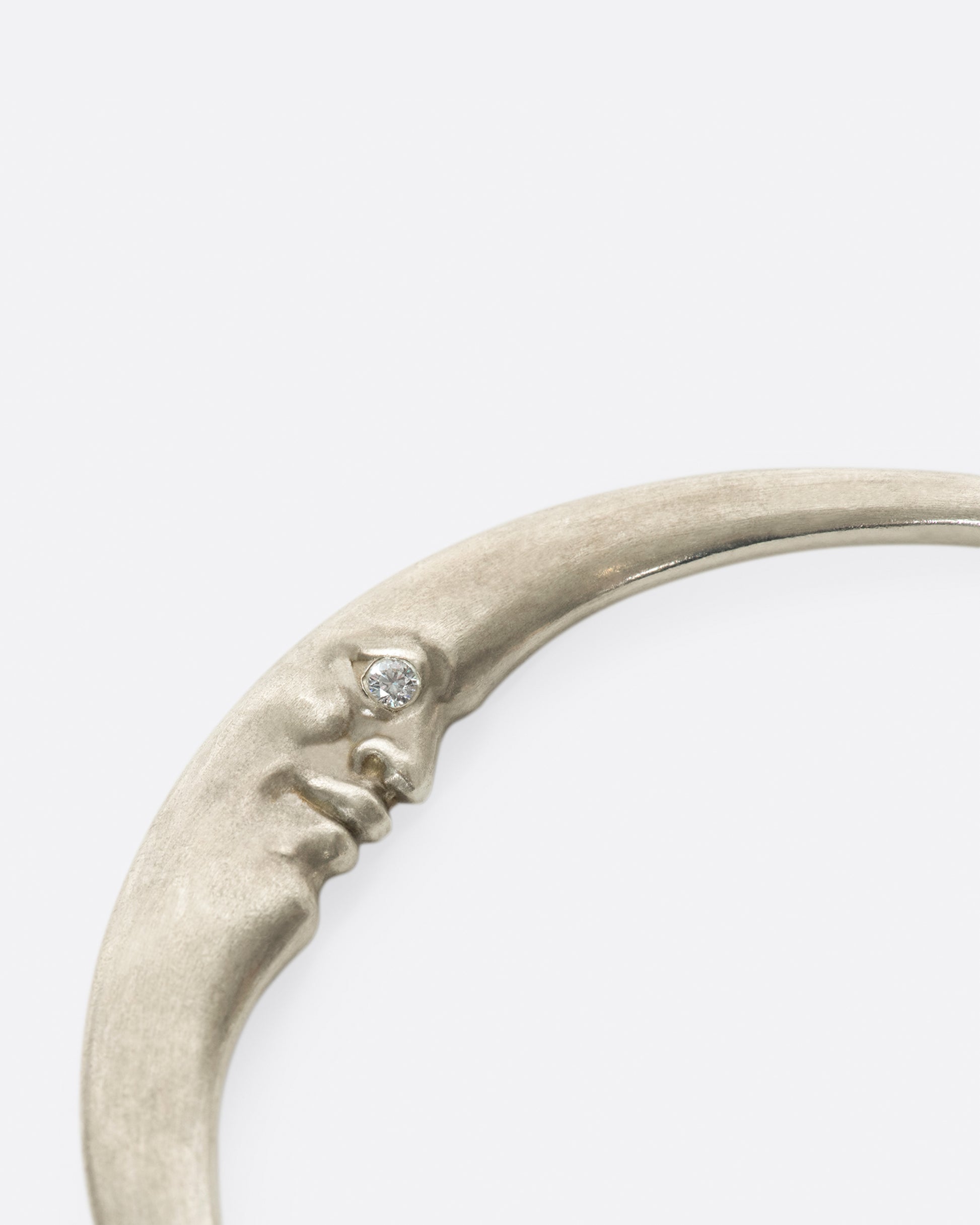A seemingly simple bangle with a hidden crescent moonface and diamond eyes, only visible from the side.