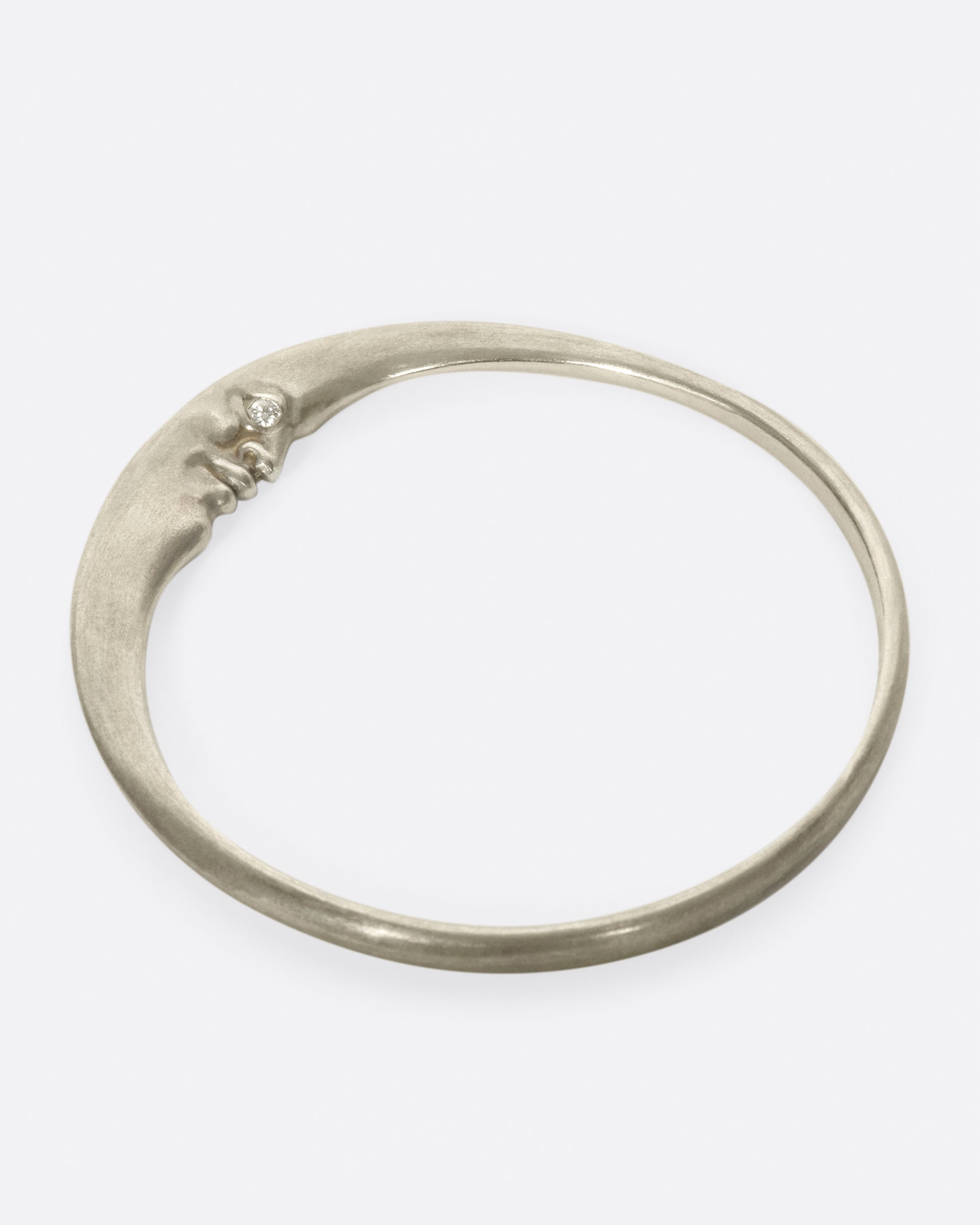 A seemingly simple bangle with a hidden crescent moonface and diamond eyes, only visible from the side.
