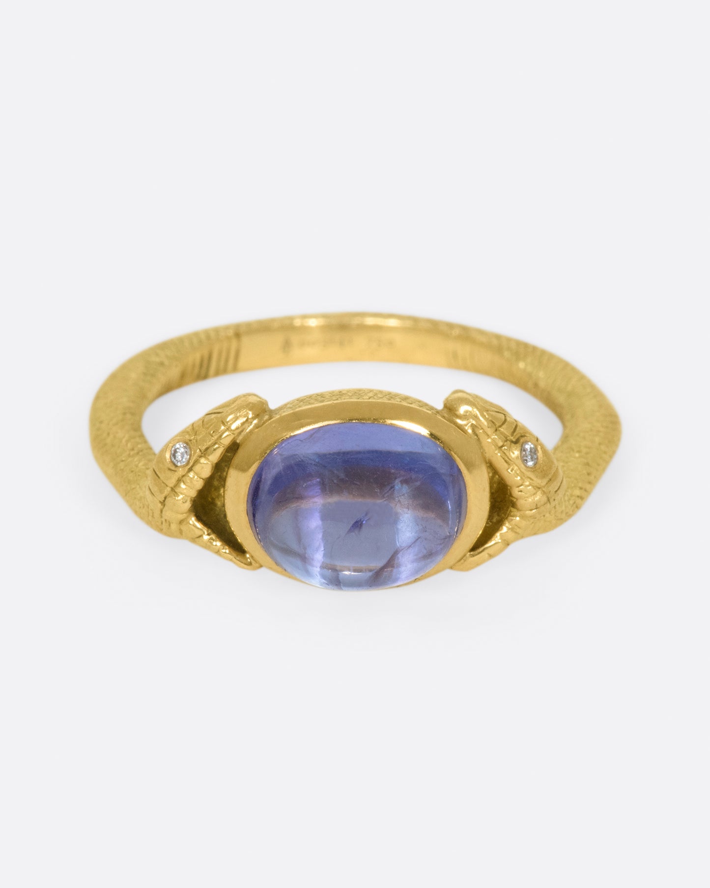 On the one hand, snakes represent Biblical personifications of evil, and on the other they symbolize health and healing; this pair encompass a saturated tanzanite cabochon.