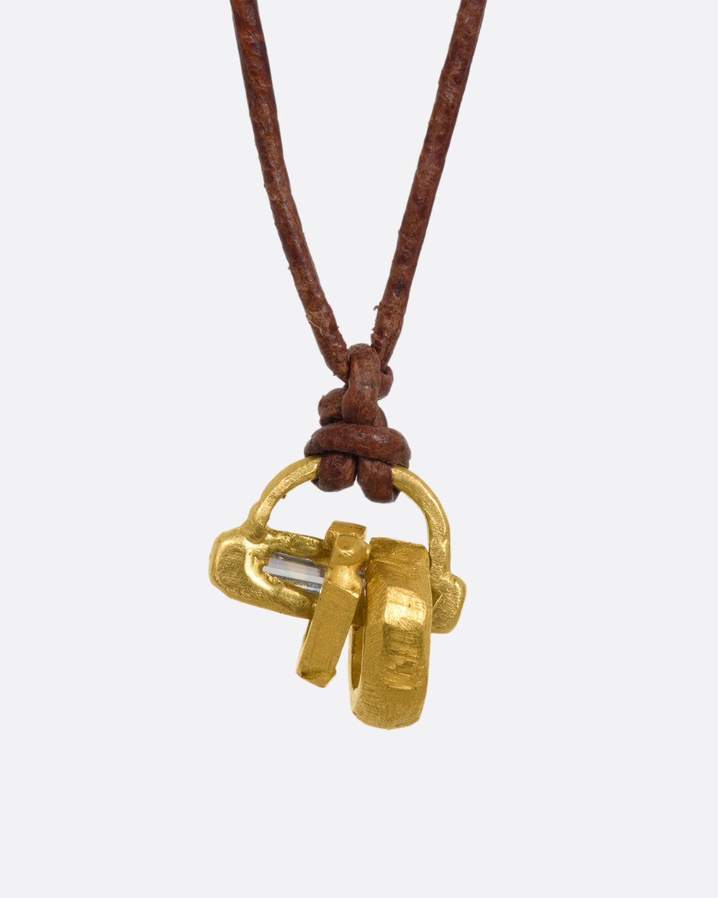 A yellow gold pendant with diamond baguette and yellow gold beads on a leather cord. View up close from the front.