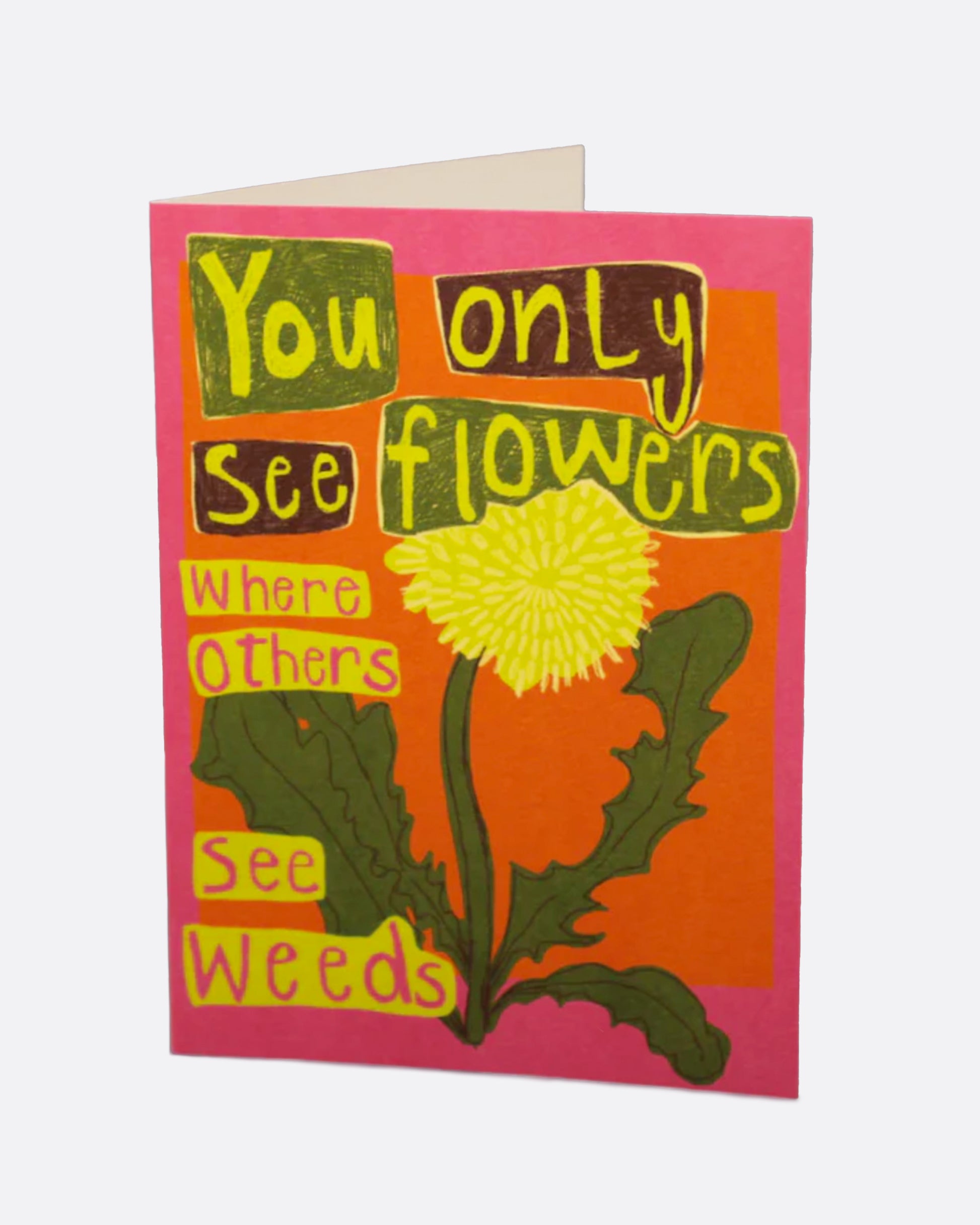 A bright pink and orange greeting card with a dandelion on the front and the words 'you only see flowers where other see weeds,' and a blank white interior.