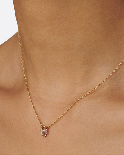 A curved gold pendant necklace with five diamond baguettes.