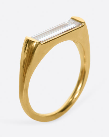 Yellow gold baguette diamond ring, angled view showing the baguette diamond set between two tapered gold ends