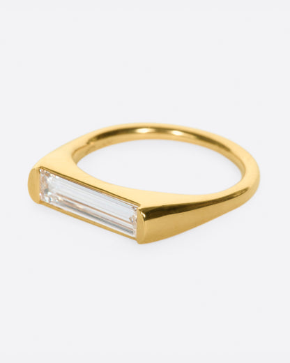 Yellow gold baguette diamond ring, side view with the baguette diamond facing left
