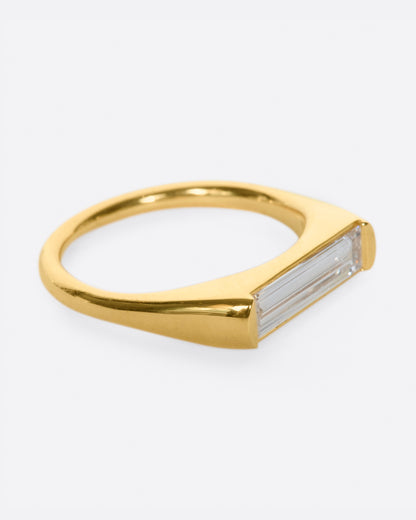 Yellow gold baguette diamond ring, side view with the baguette diamond facing right