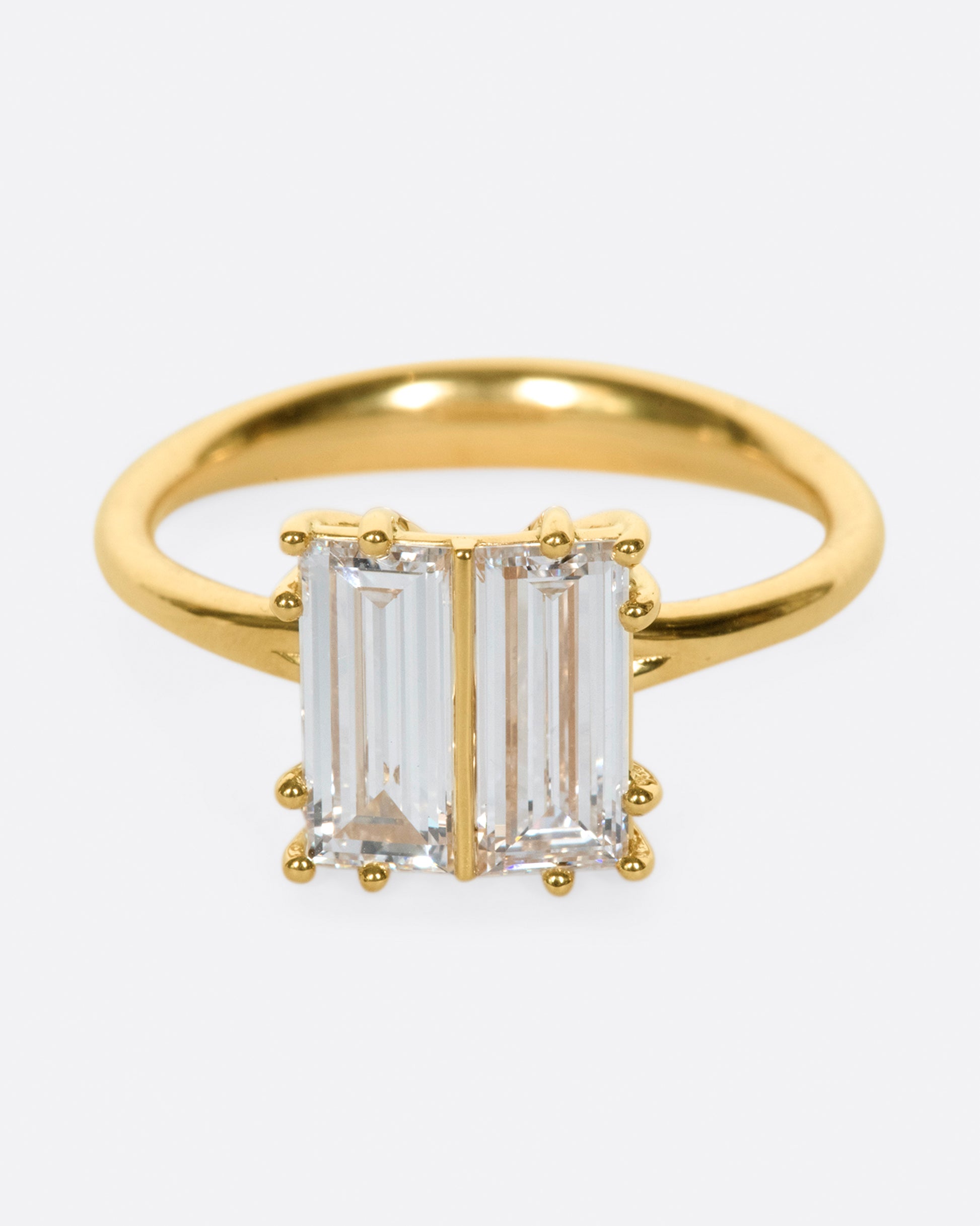 A modern Toi et Moi ring, this symmetrical style shows off two large baguette diamonds set in hand formed prong settings.
