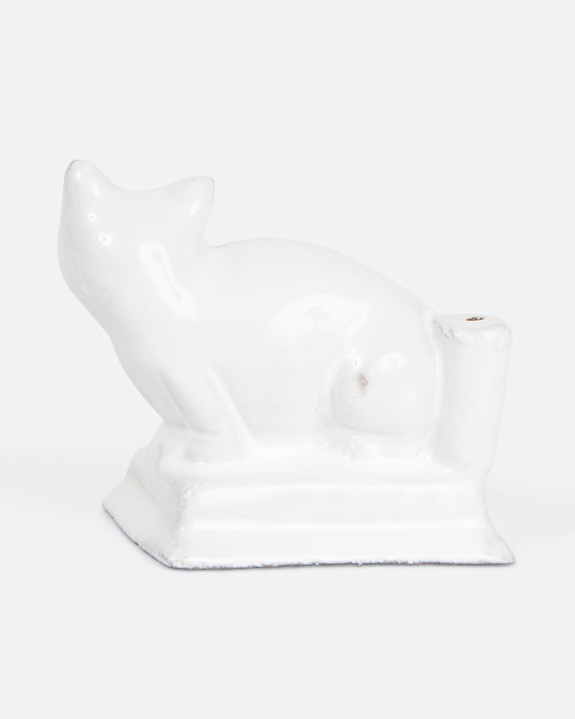 A glazed white ceramic cat-shaped incense holder, shown from the back.