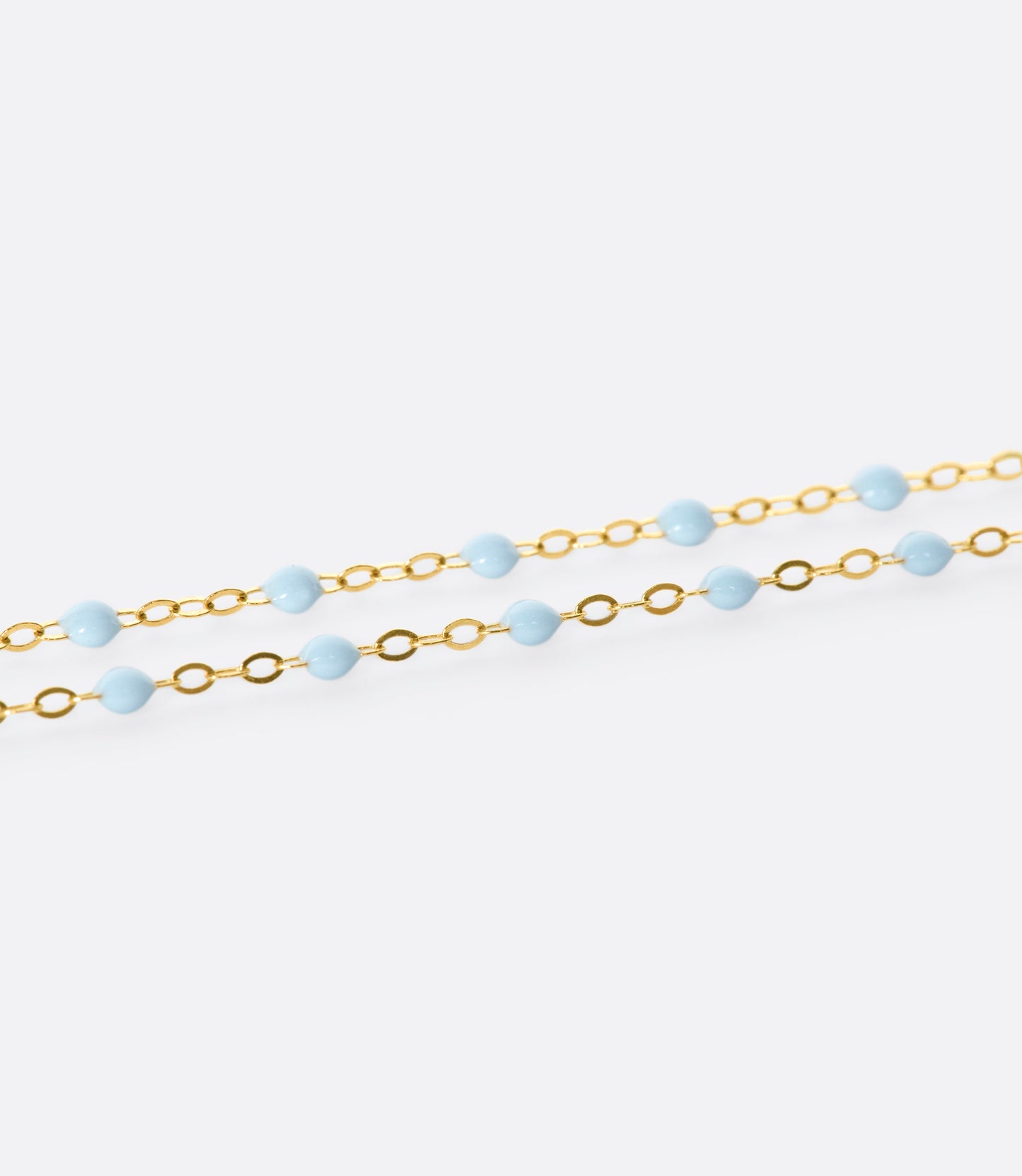 A thin yellow gold chain necklace with resin beads. Each necklace is hand dipped in melted resin to create the beaded effect. 