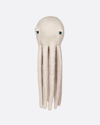 A stuffed plush oatmeal colored octopus with blue eyes and a fuzzy belly. Shown from the front.