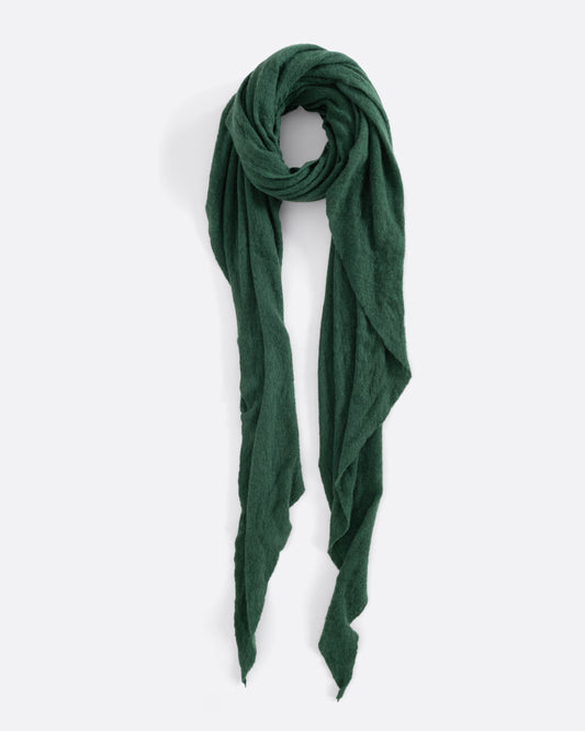 A green cashmere scarf, tied in a loop, laying flat.