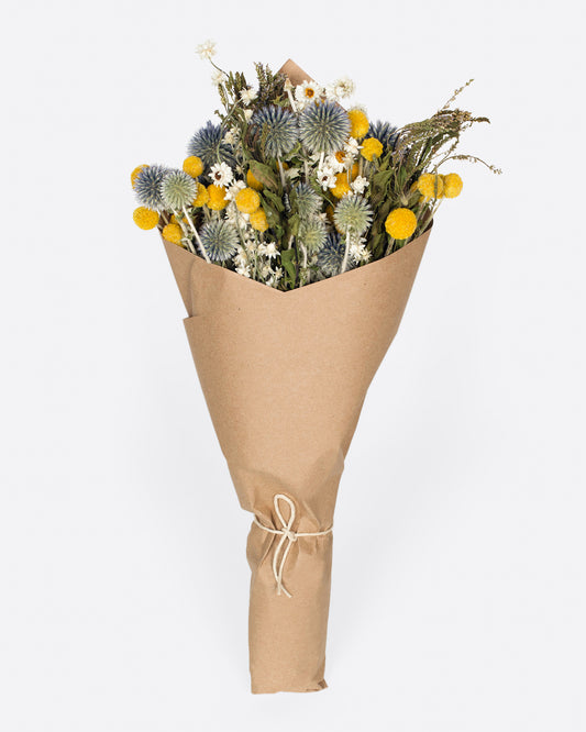 A hand arranged bouquet with assorted shades of yellow, green, and blue.