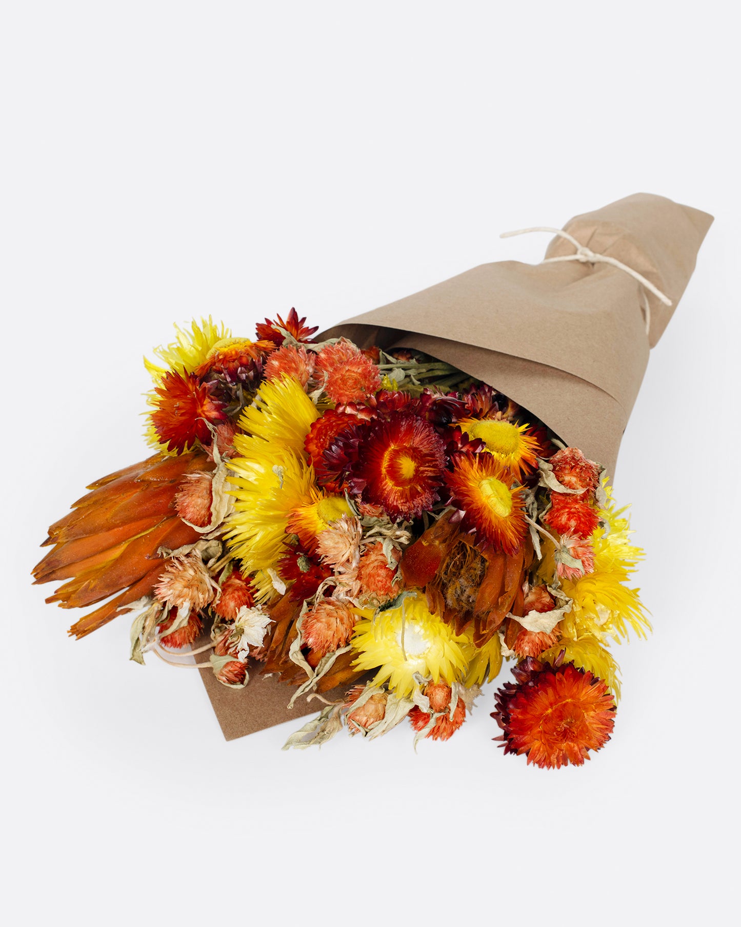 A warm dried floral arrangement of reds and yellows.