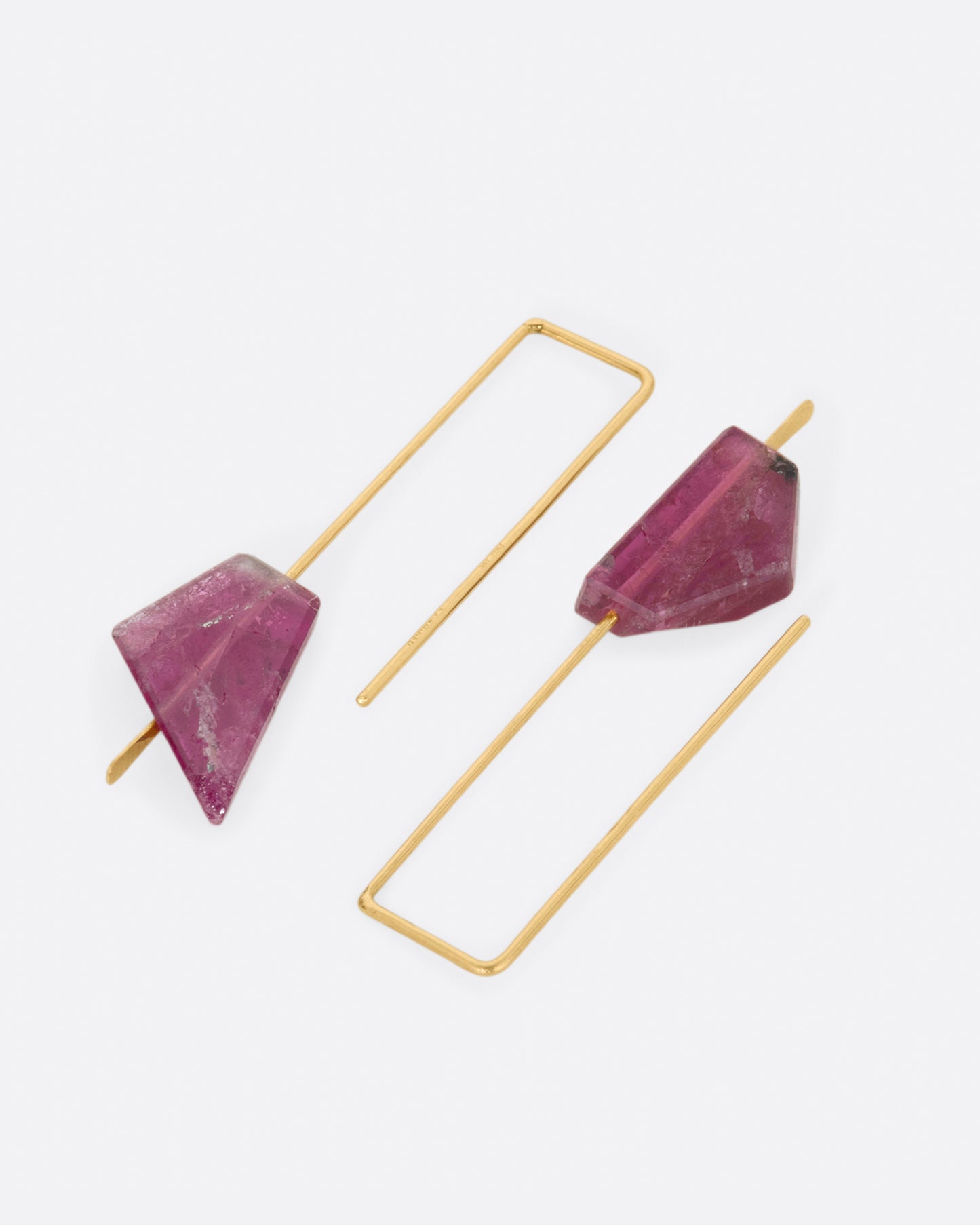 Yellow gold rectangular hook earrings with a single deep pink tourmaline on each. View laying flat.