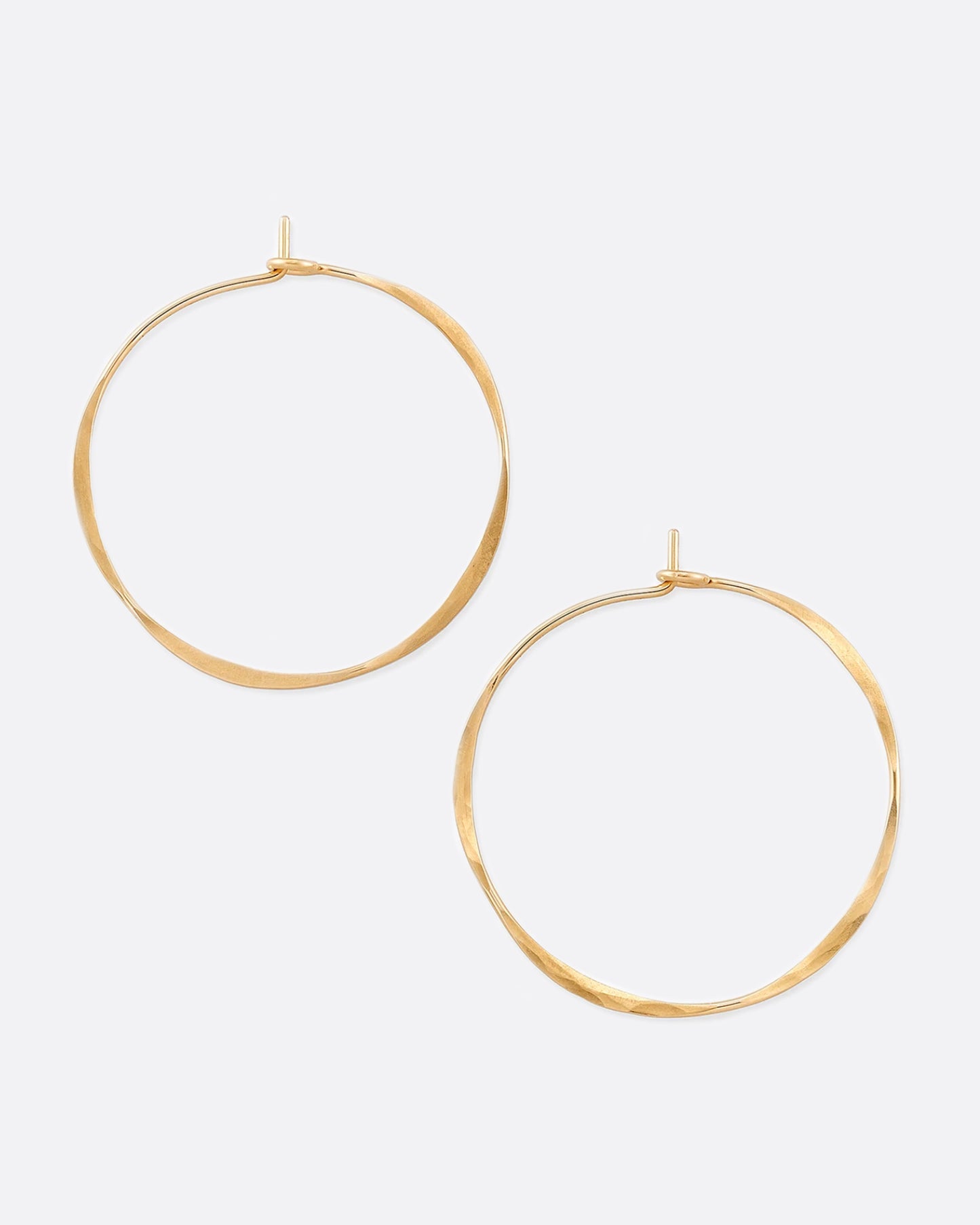Hand-hammered yellow gold hoops with a comfortable hook closure.