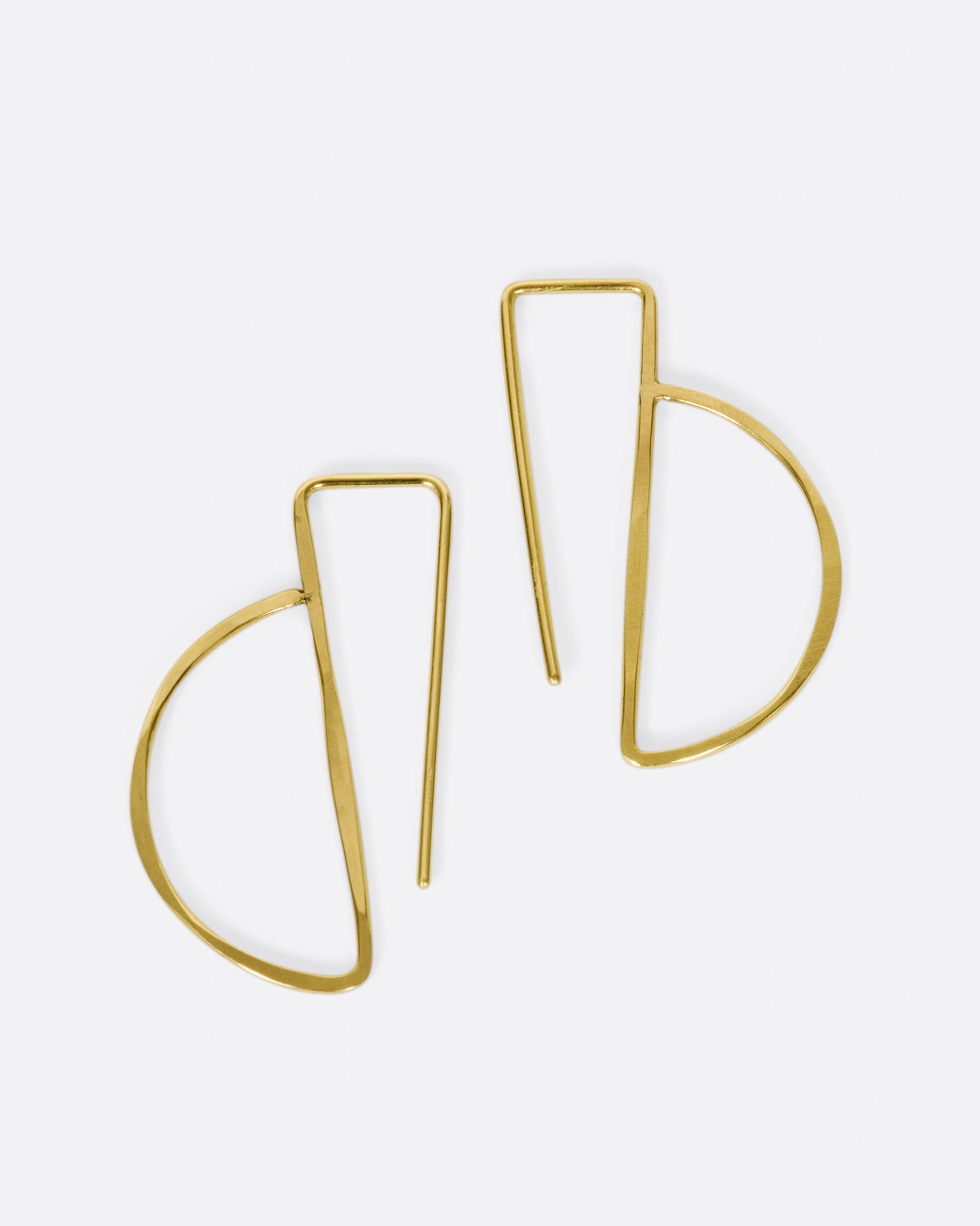 These hammered gold earrings thread through the ear so that the straight bar sits comfortably behind your lobe and the curve shows in front.