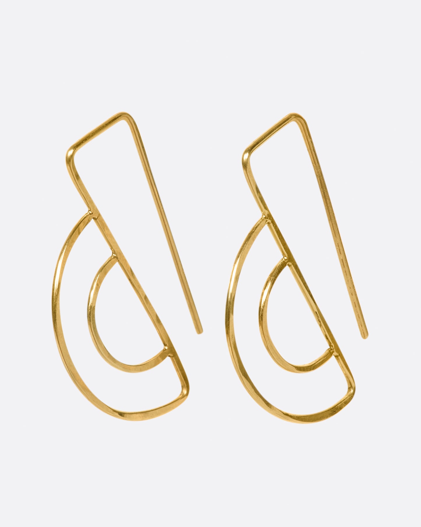 These double semi-circle earrings face forward and the long straight wires hang behind the earlobe; framing the face.