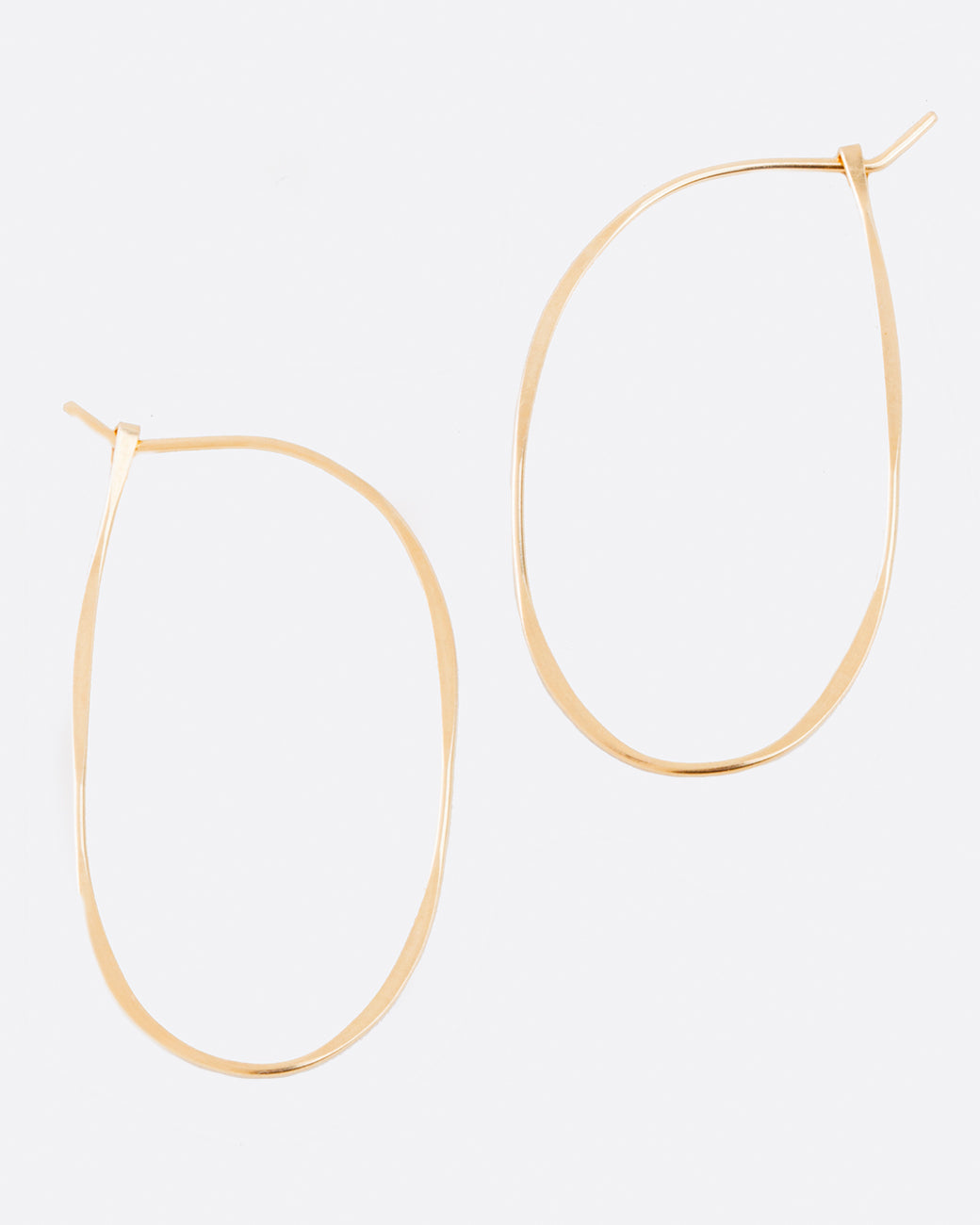 Hammered, off-center, oval hoops that close upon themselves.
