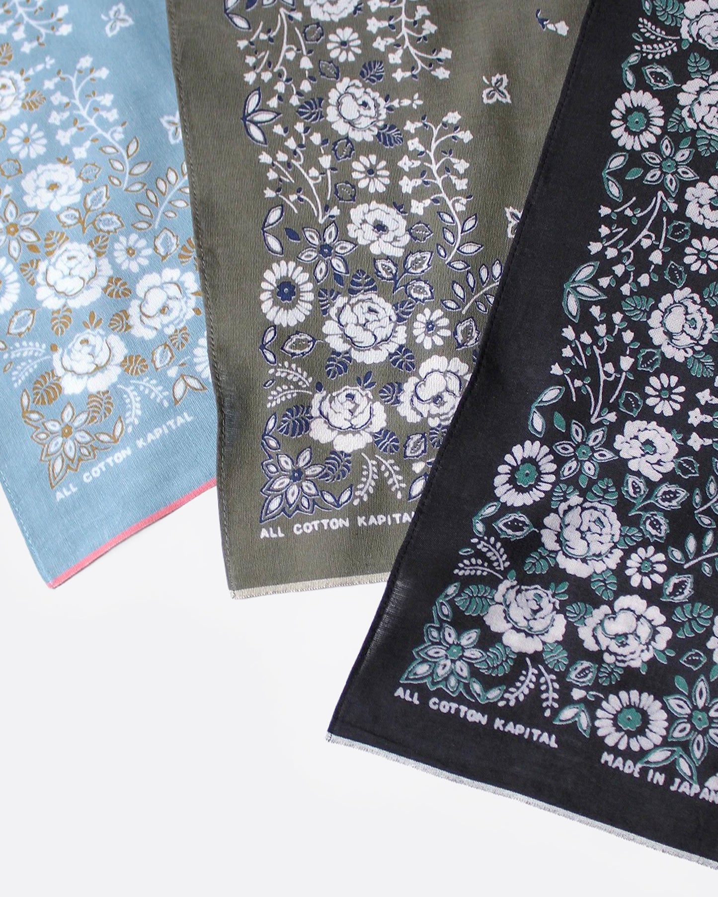 Three floral-patterned bandanas in blue, green, and black, shown close up