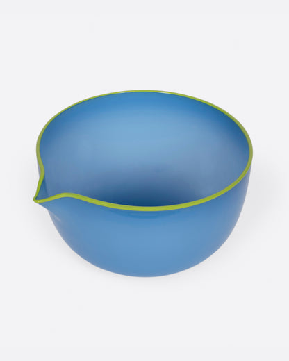 A hand blown blue glass spouted bowl with a chartreuse edge. Shown from the top.