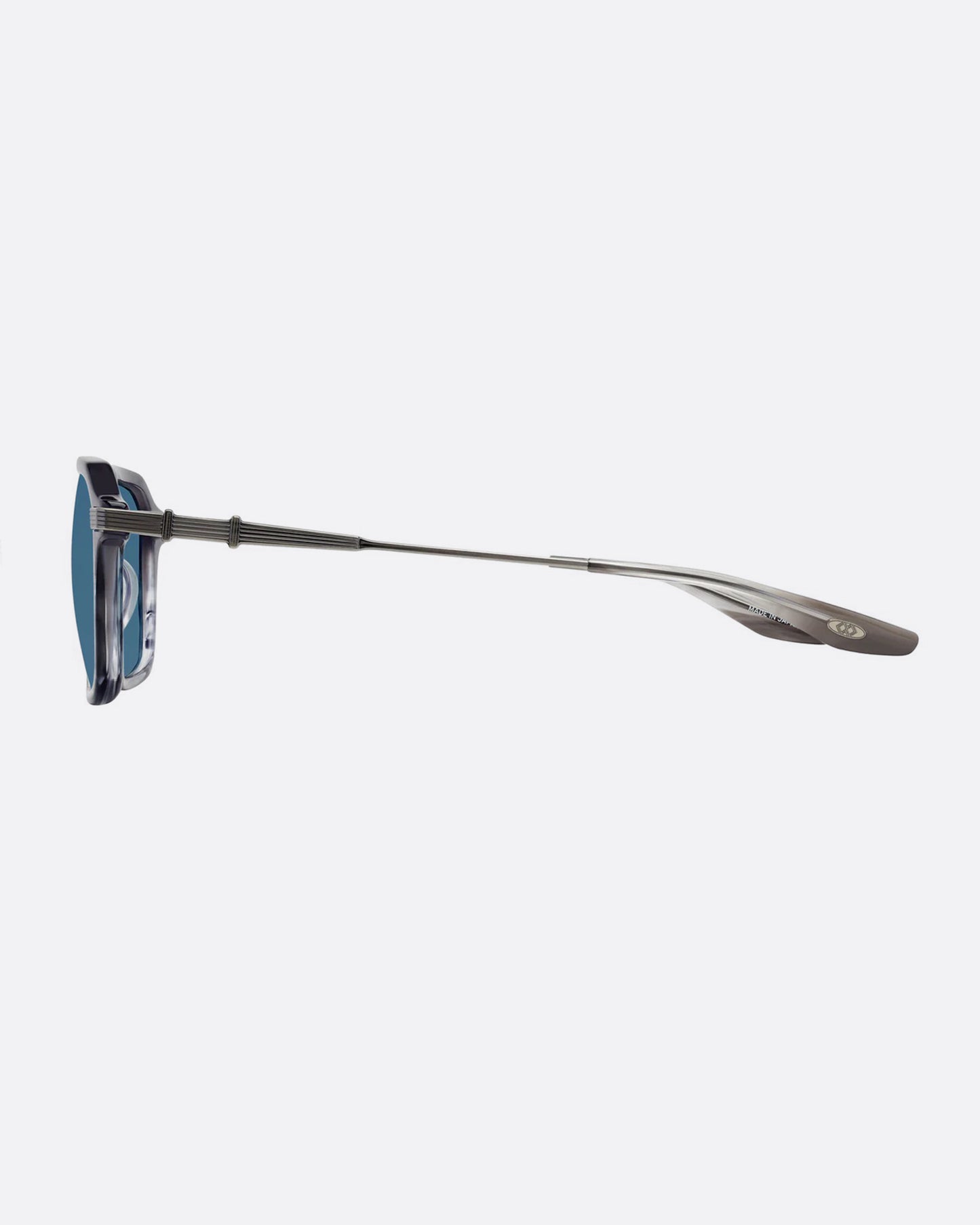 A pair of sunglasses with pearl gray frames and blue lenses. Shown from the side.